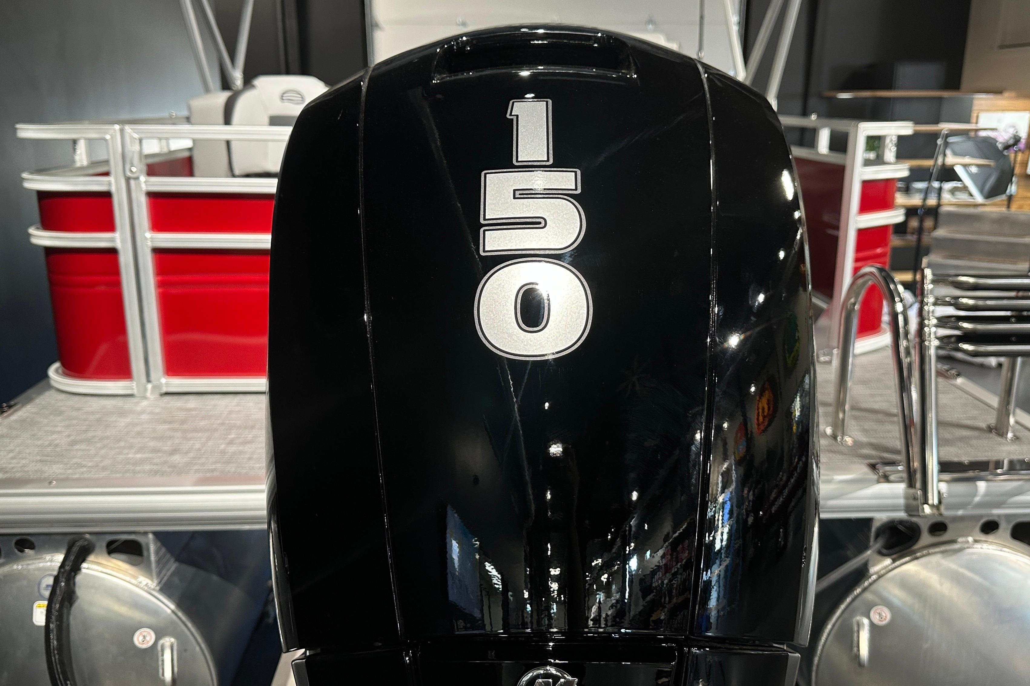 Outboard motor on 2026 Sun Tracker SportFish 22 DLX pontoon boat, red and silver design.