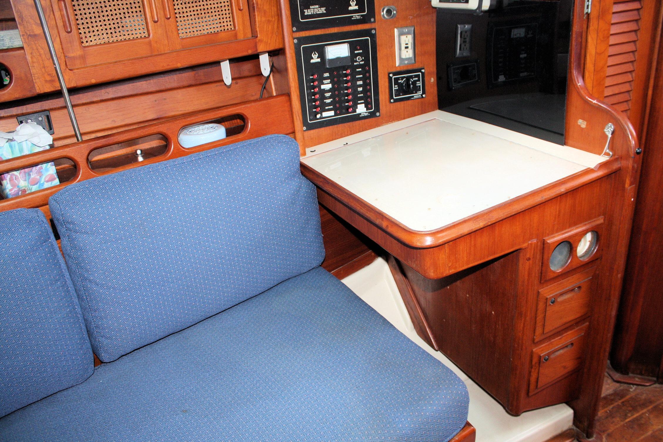 Interior of a 1987 Ericson 38-200 sailboat with blue seating and navigation station.