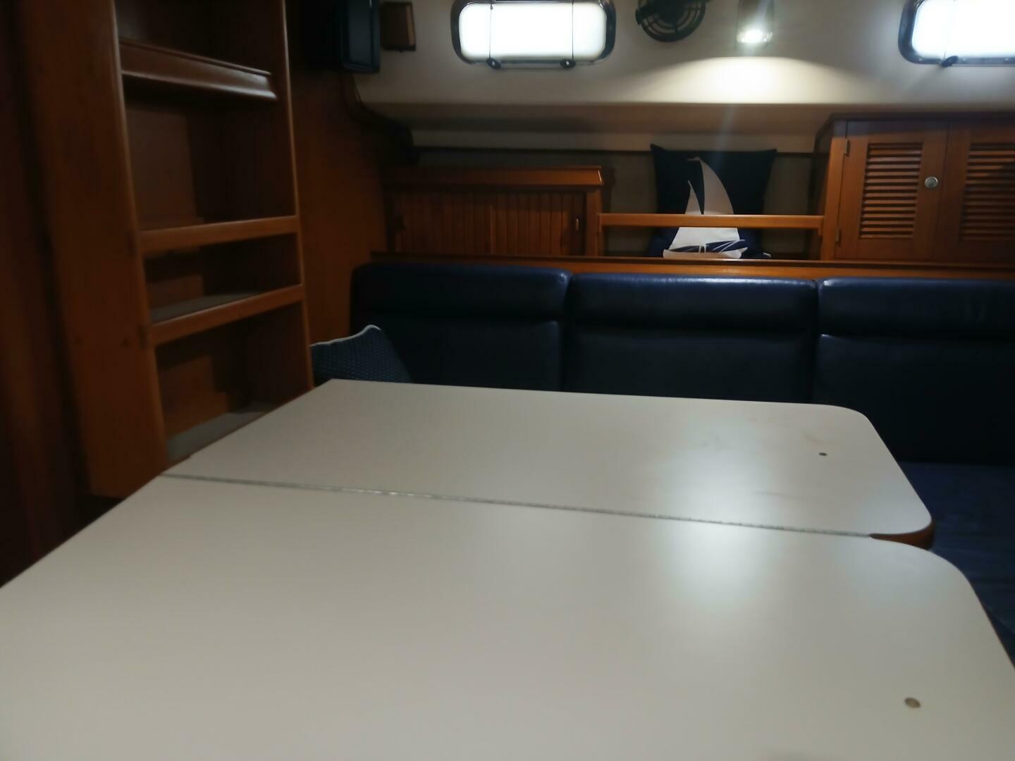 Interior of 1999 Island Packet 45 sailboat with table, seating, and wooden cabinetry.