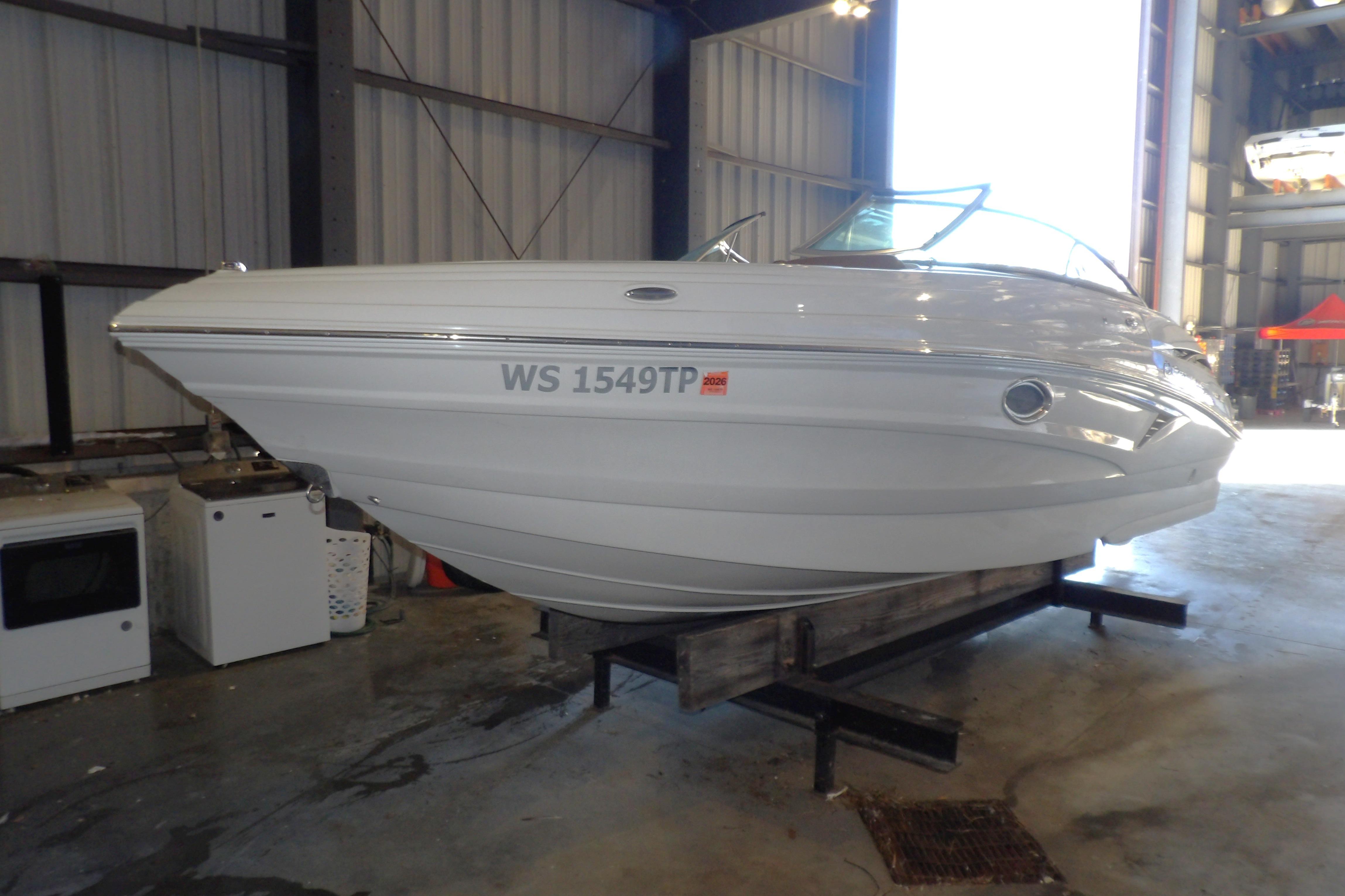 2023 Crownline 250 XSS boat in a storage facility, side view.