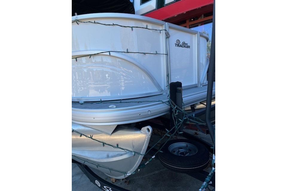 2026 Sun Tracker Party Barge 16 DLX pontoon boat with decorative lights.