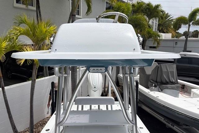 2025 Contender 26 Bay boat console with steering wheel, surrounded by palm trees.