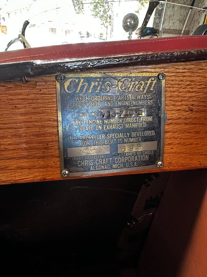 Brass plaque on a wooden boat with Chris-Craft logo and technical instructions.