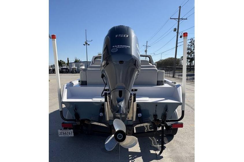 1997 Scully's 18 WT boat with a 150 HP outboard motor, parked on a trailer.