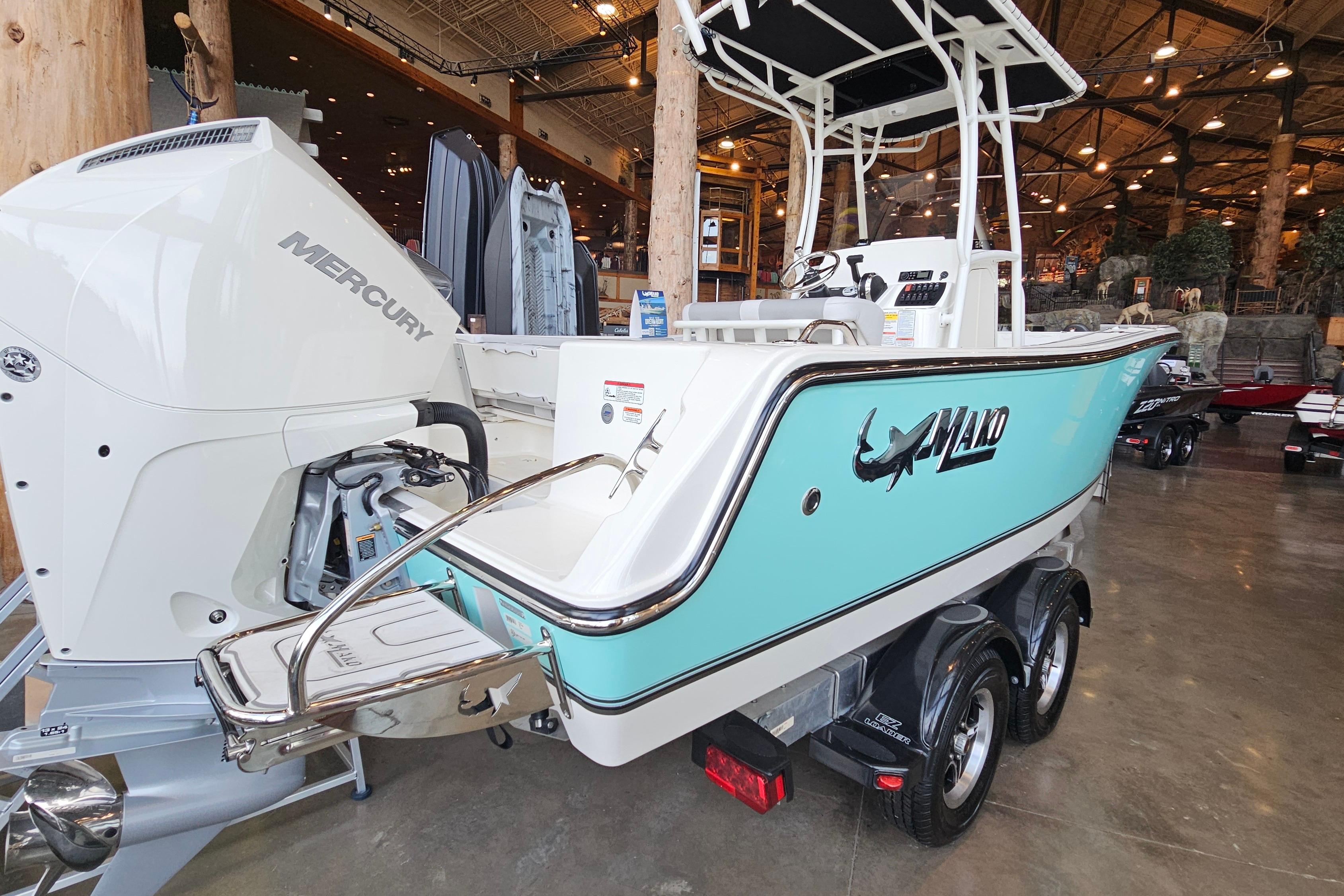 2025 Mako 214 Center Console boat with Mercury engine, displayed indoors on a trailer.