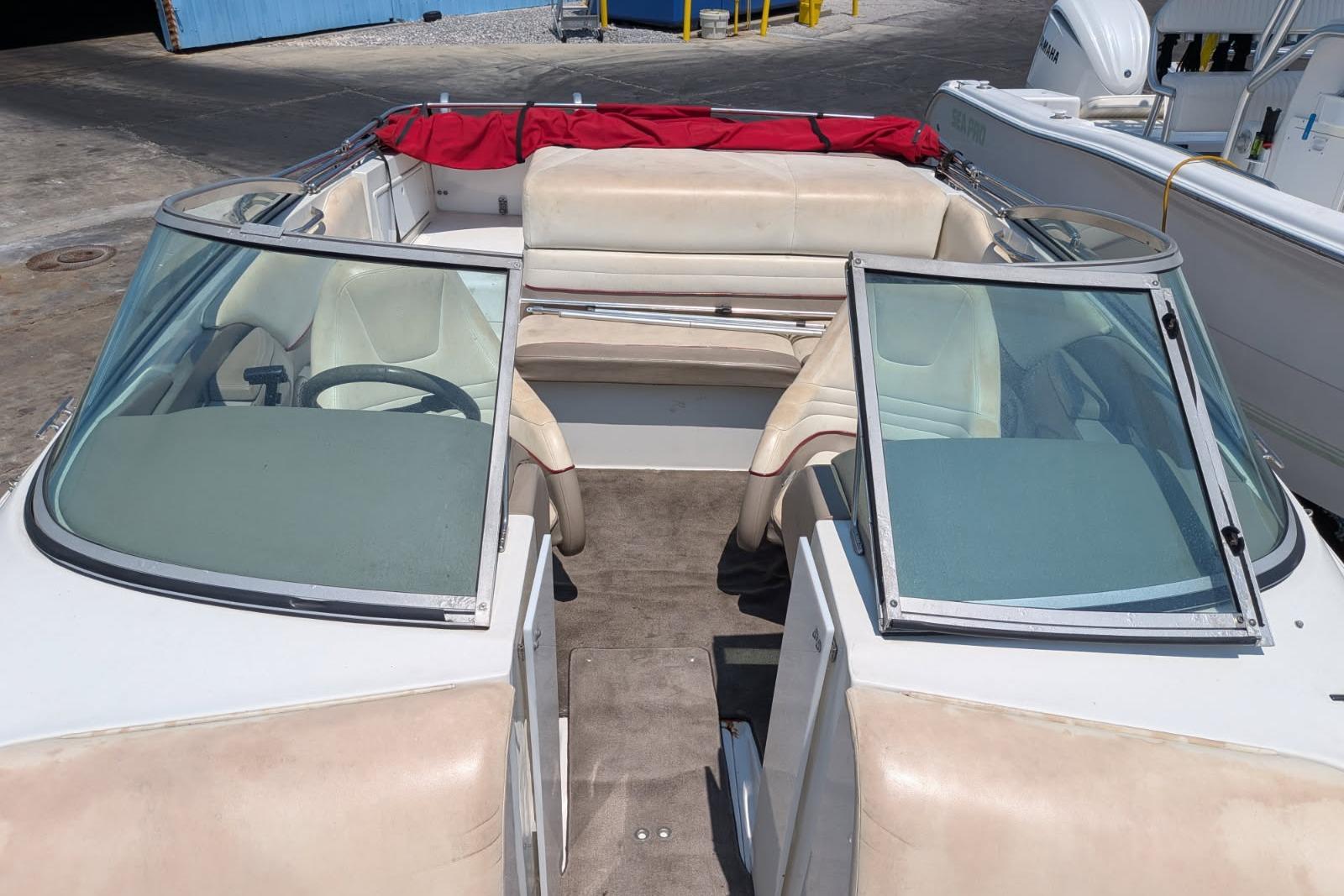 2020 Cobalt 206 boat interior with beige seating and red cover, docked outdoors.