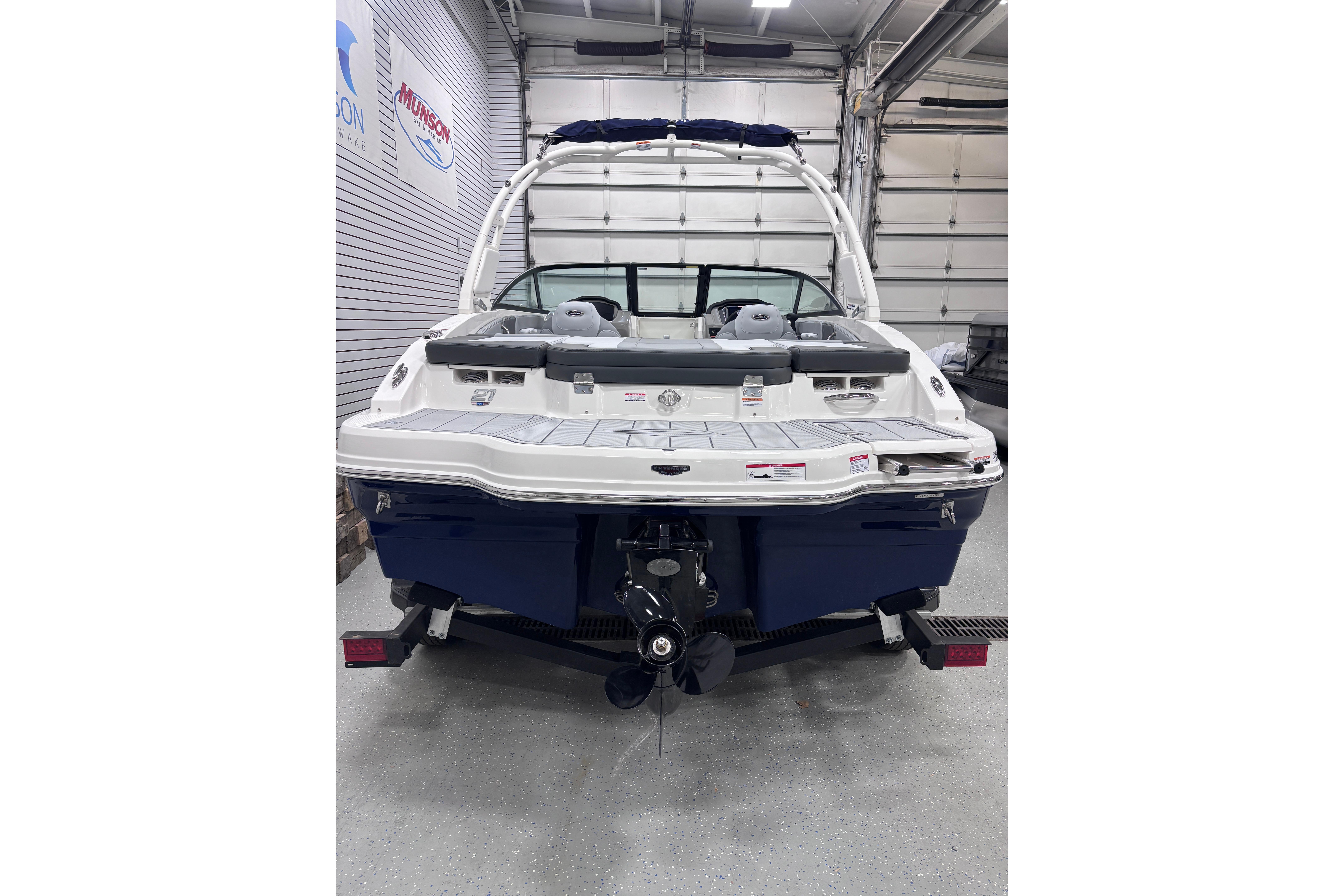 2026 Chaparral 21 SSi boat in showroom, rear view with outboard motor.