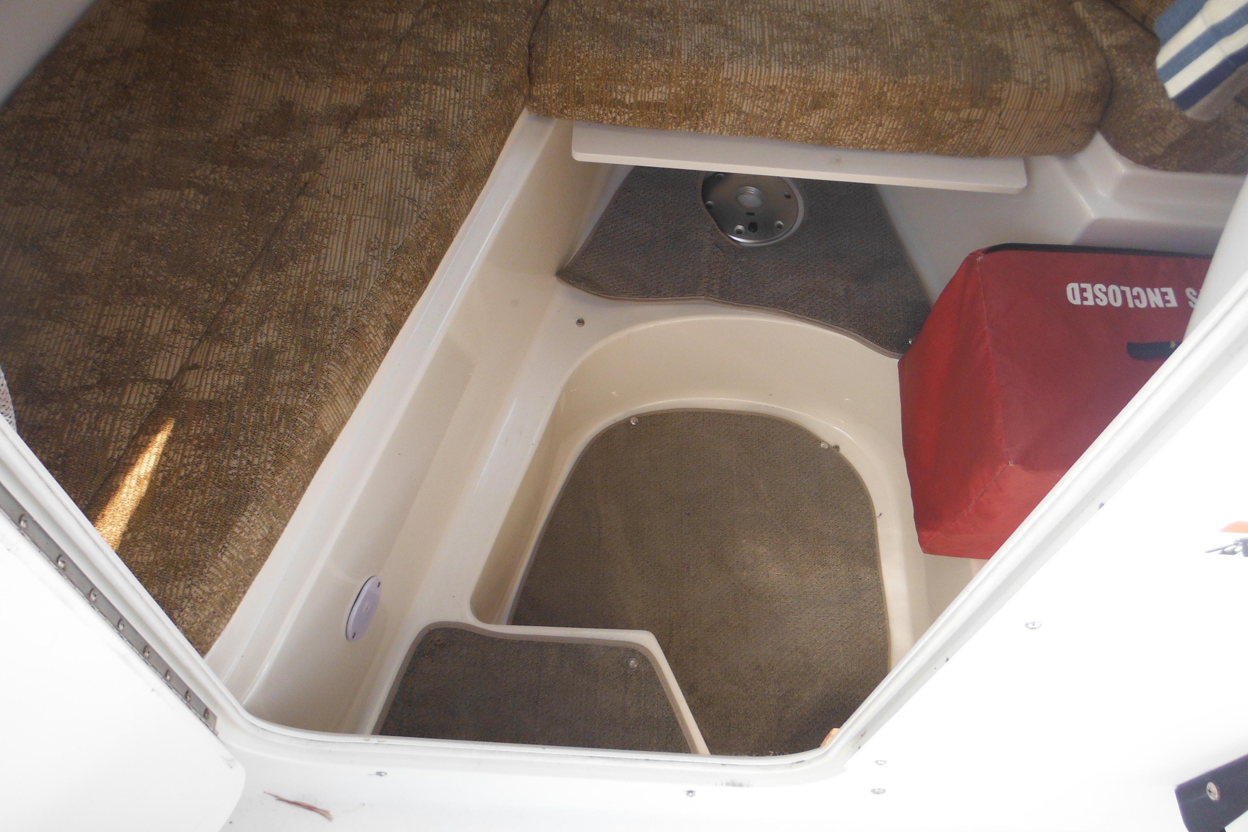 2005 Seaswirl Striper 2101 Walkaround O/B cabin interior with seating and storage.