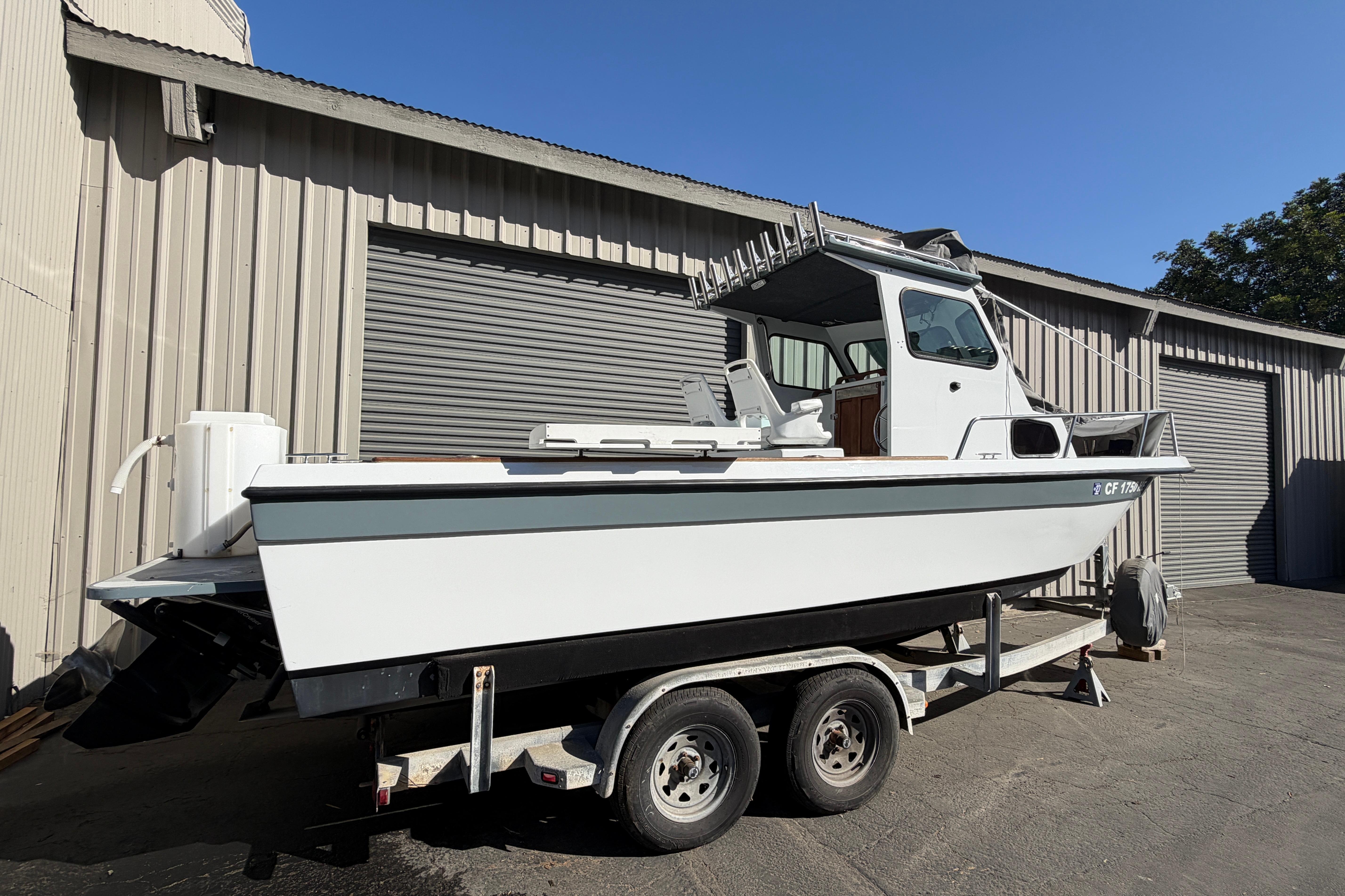 1986 Radon 21 Sport boat on trailer, parked outside a metal building.