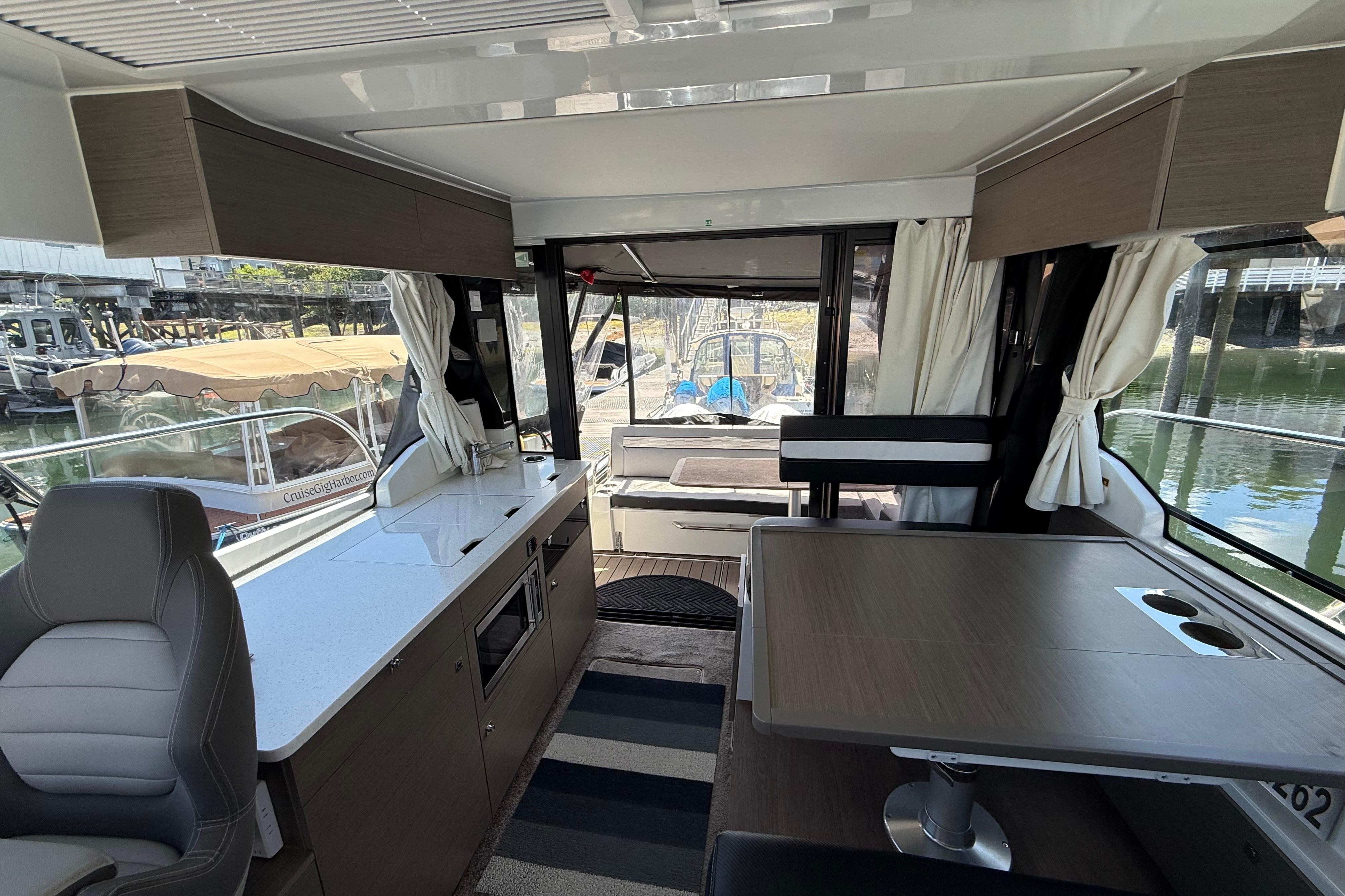 Interior of 2024 Jeanneau NC 1095 Coupe, featuring modern seating and dining area.