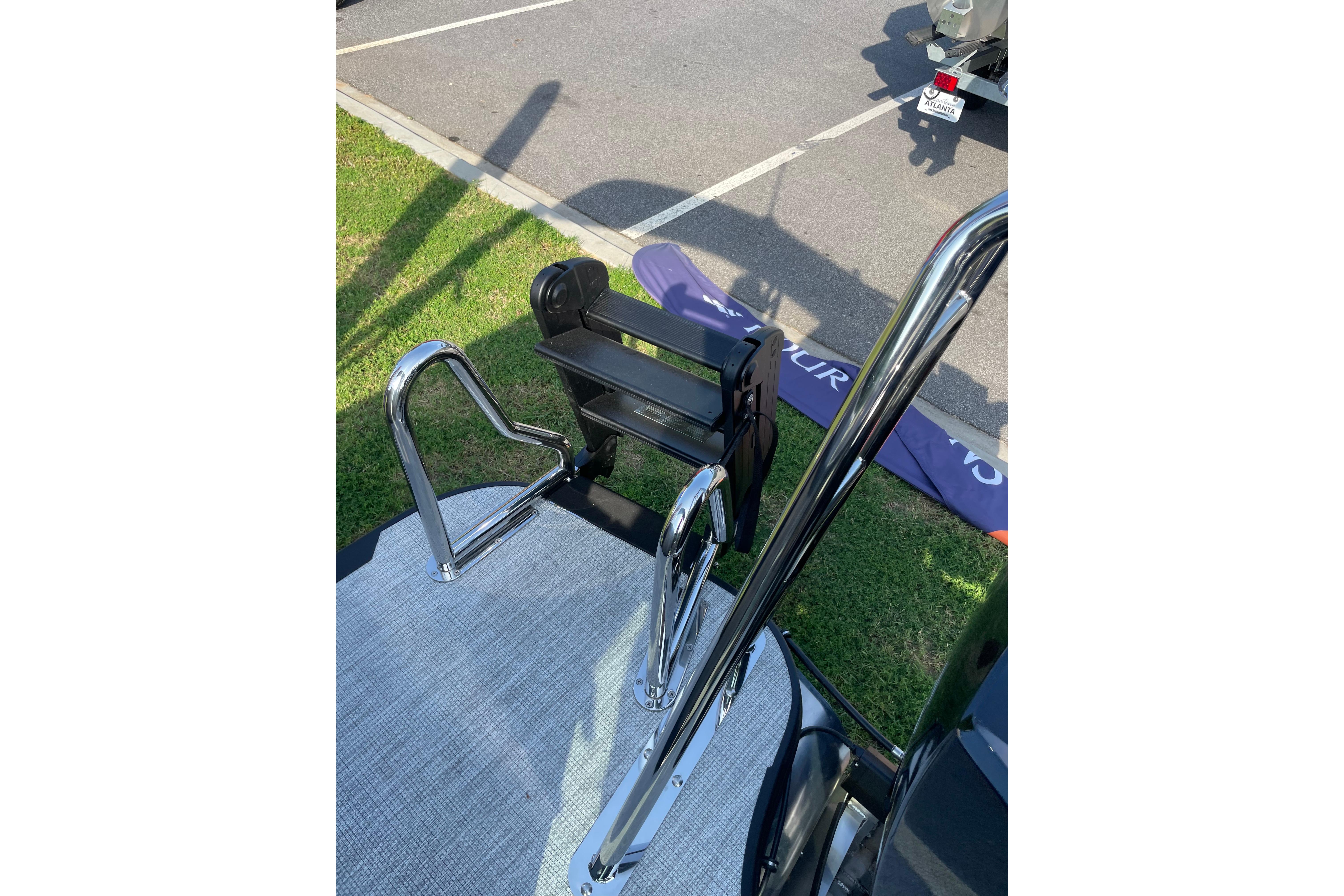 Chrome boat ladder on Alera a24, 2027 model, parked on grass near pavement.