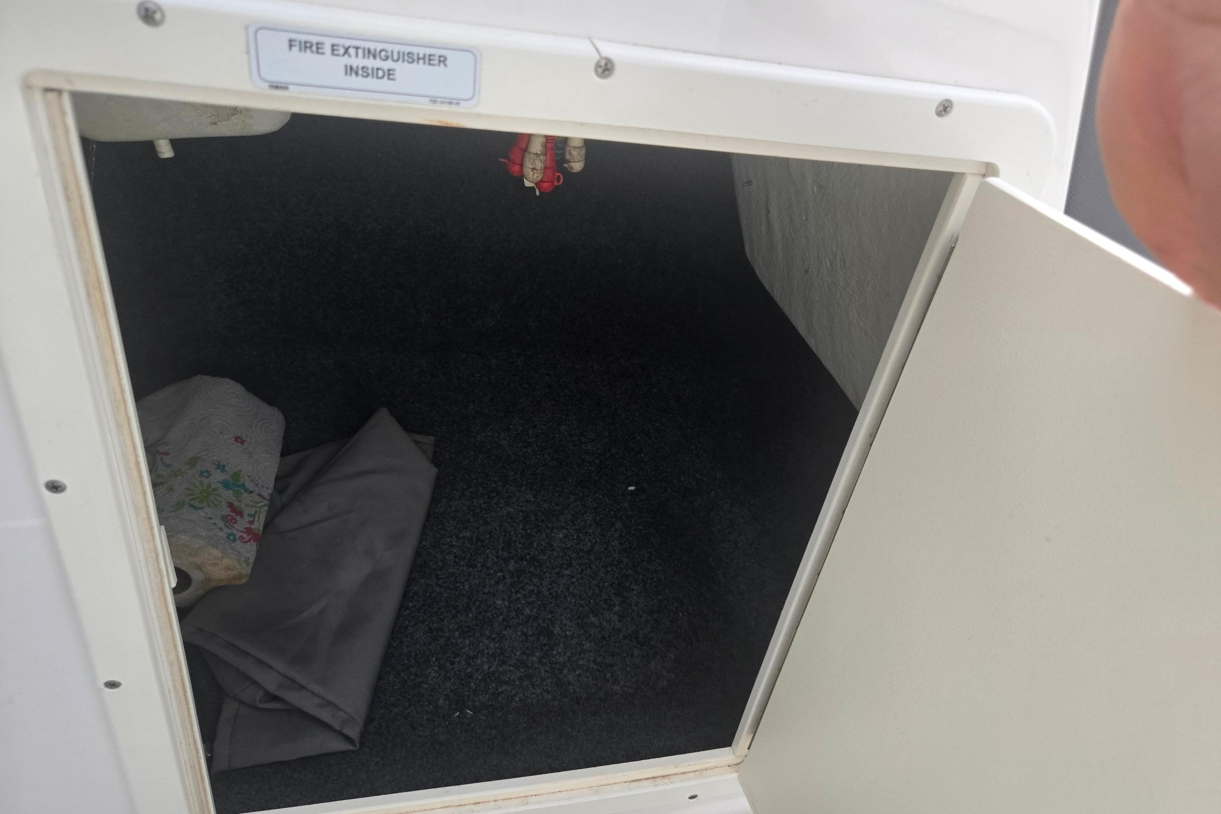 Open storage compartment on 2016 Yamaha AR192 boat, labeled for fire extinguisher storage.