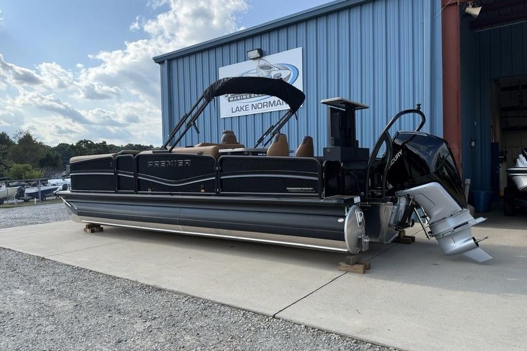 2026 Premier 250 Solaris RS CL pontoon boat parked outside a blue building.