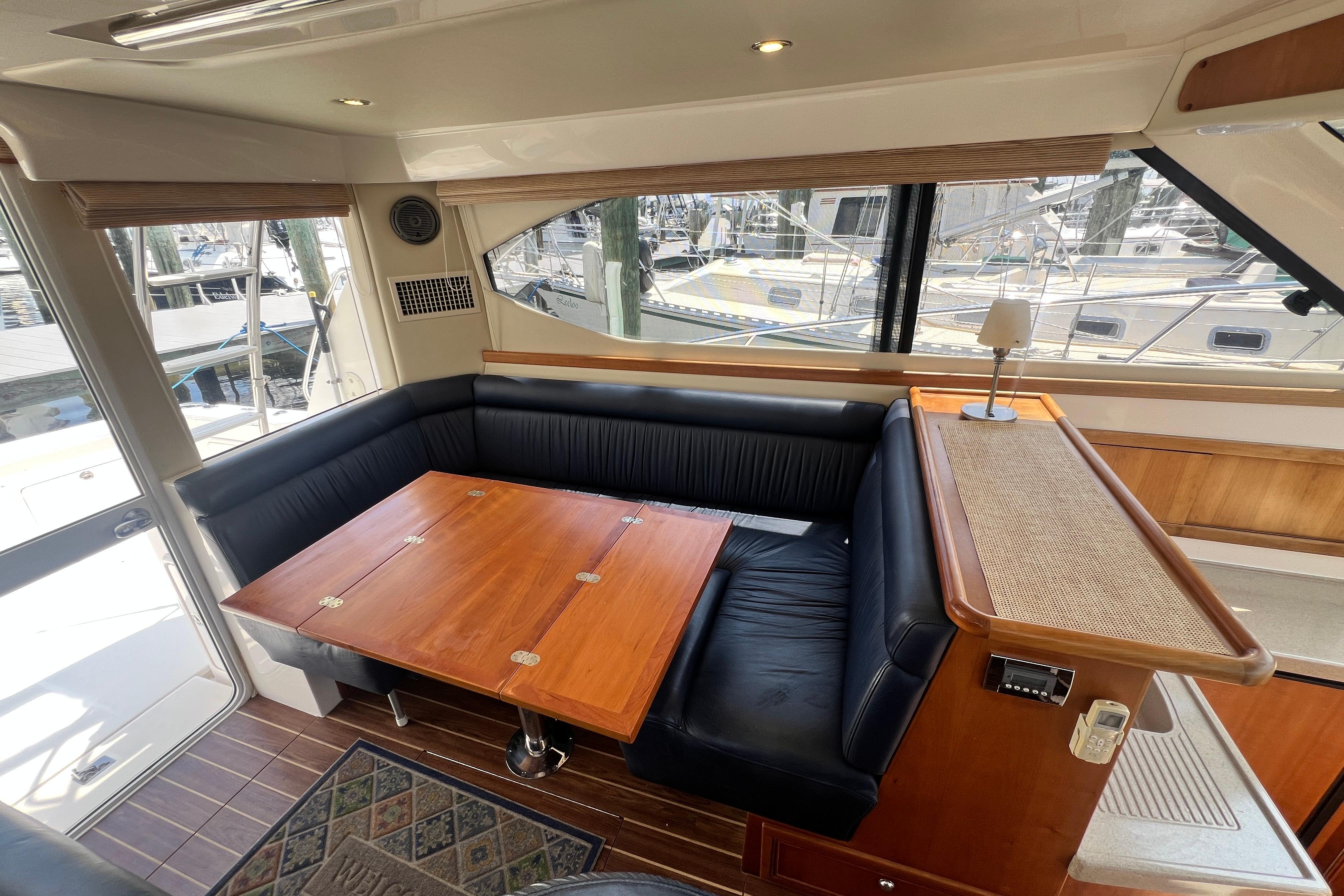 Interior of 2007 Riviera 33 Flybridge yacht with elegant seating and wooden table.
