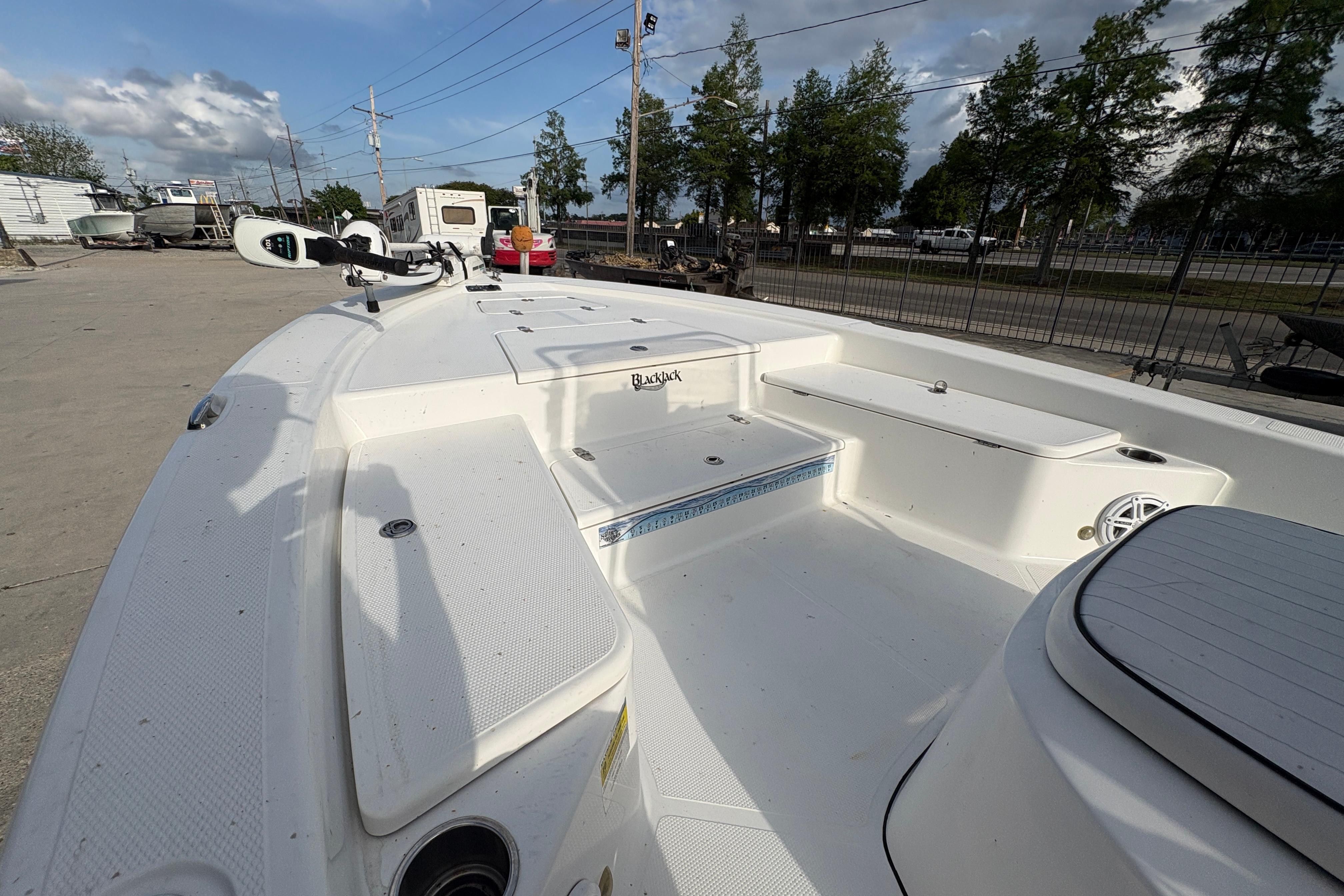 2012 BlackJack 224 boat deck with seating and storage, parked outdoors.