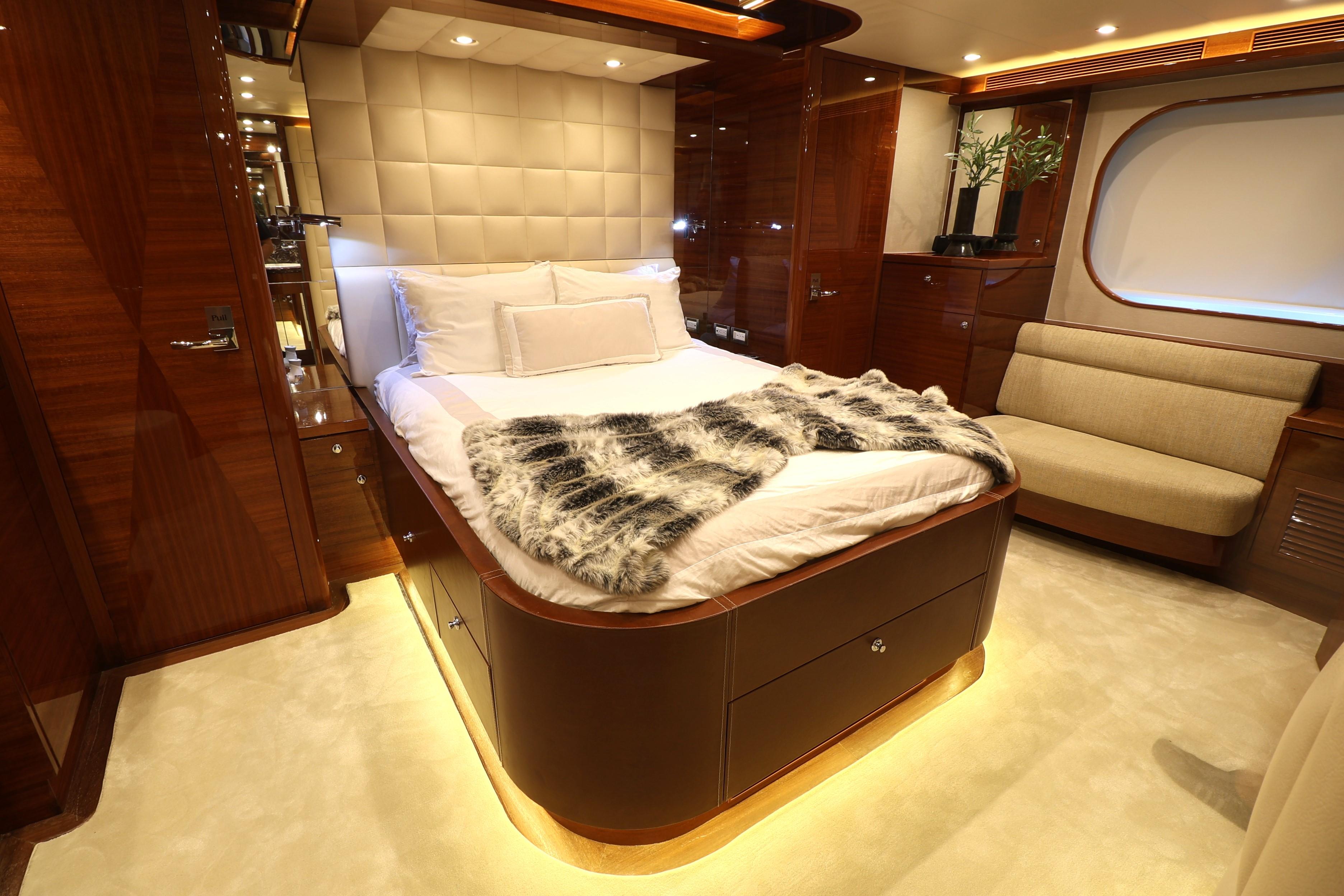 Luxurious 2013 Cheoy Lee Bravo yacht bedroom with elegant wood finishes and plush bedding.