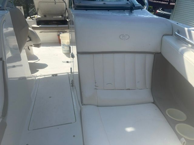 The image shows the cockpit of a 2003 Cobalt 240 boat with white upholstered seating.