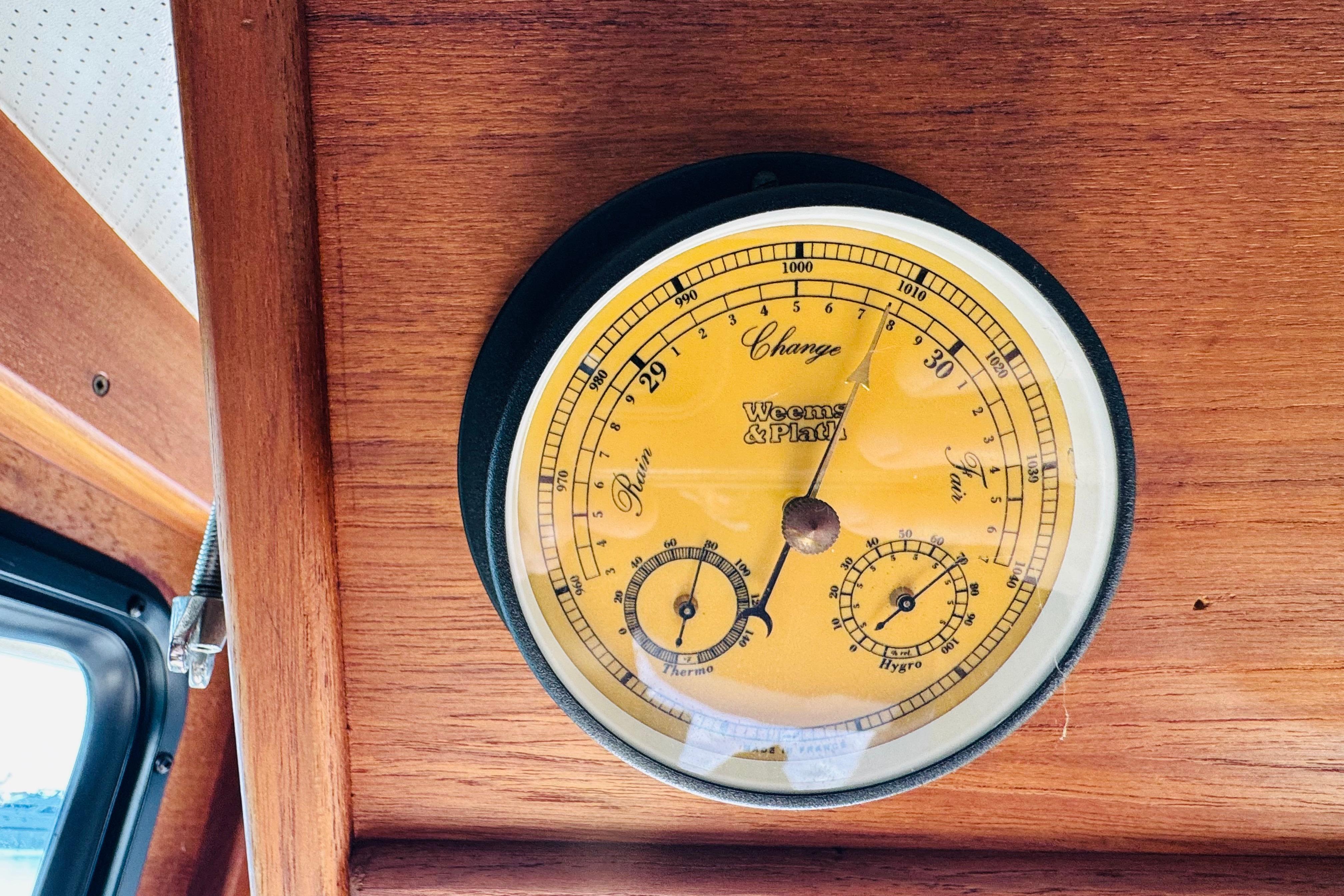 Barometer on 1996 Nordic Tug 32 wooden interior, displaying atmospheric pressure.