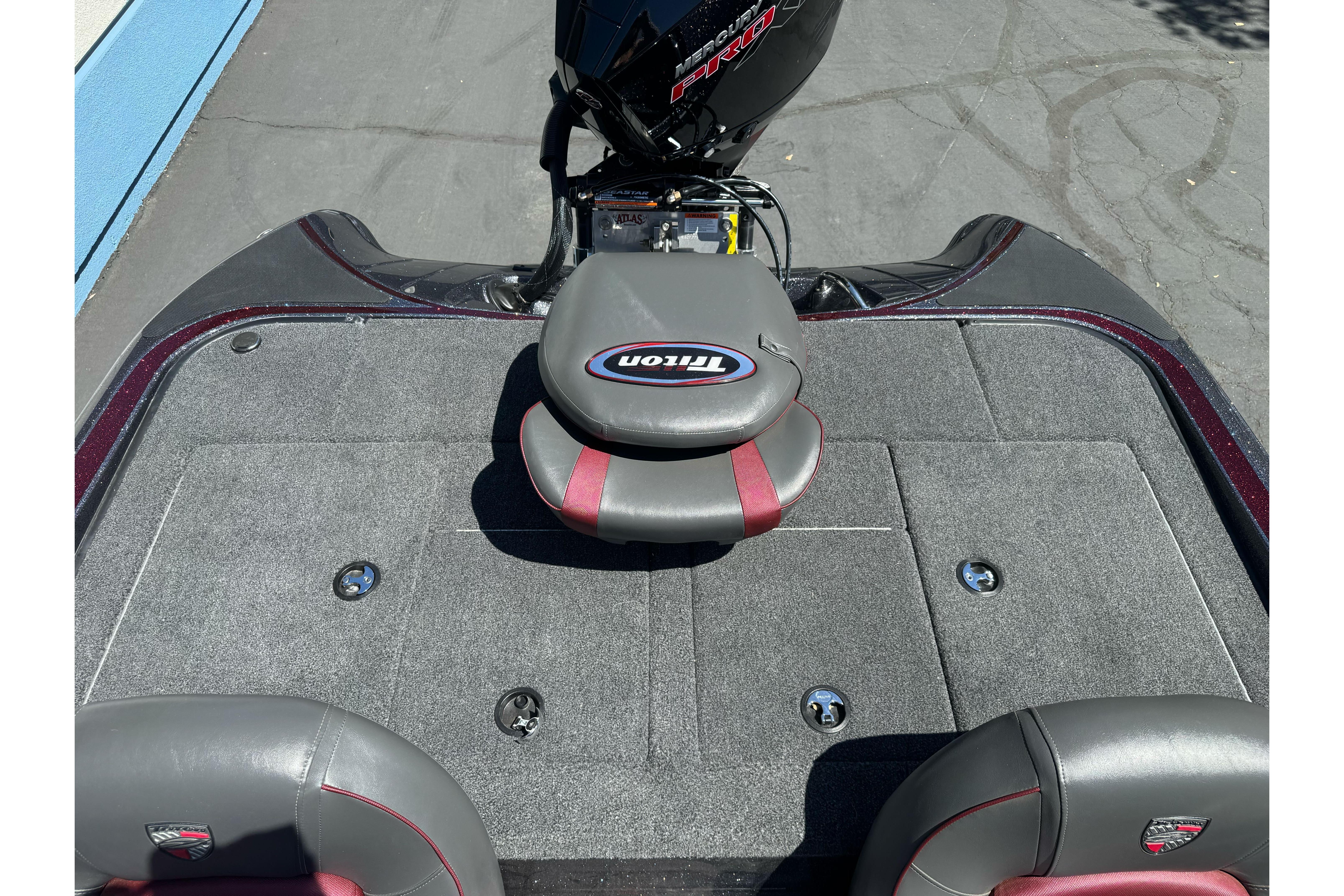 2026 Triton 18 TrX boat interior with gray and red seating, showcasing storage compartments.