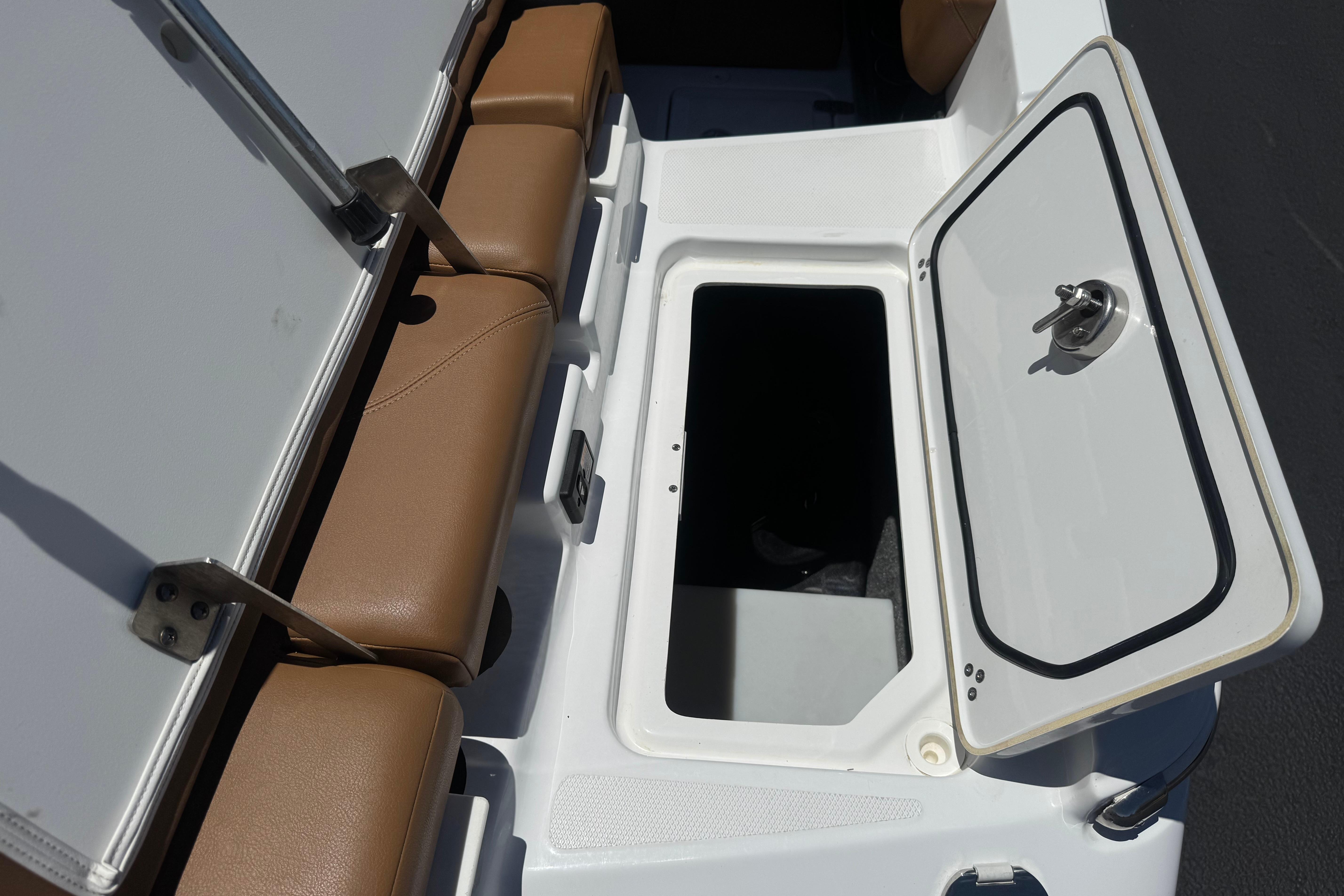 2022 Four Winns H4 boat interior storage compartment with open hatch and cushioned seating.
