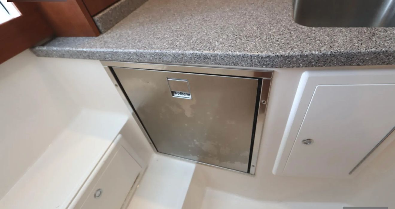 Galley area with stainless steel refrigerator and granite countertop.