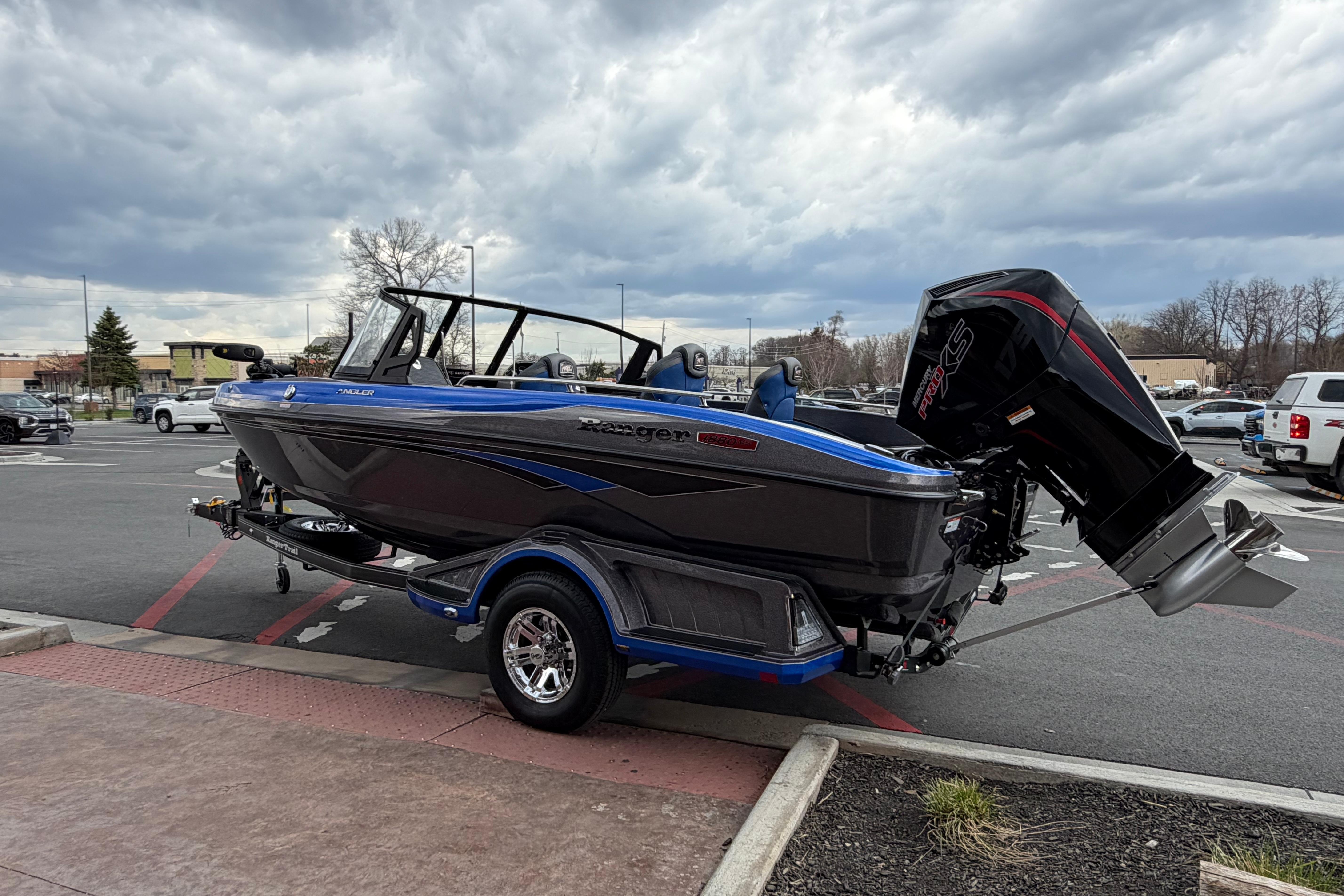 2026 Ranger 1880MS boat with powerful outboard motor in a parking lot under cloudy skies.