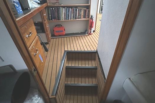 Interior of 1990 Cutter TDM Center Cockpit Cutter with wooden flooring and bookshelves.