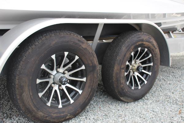 2023 Scarab 255 Open ID trailer wheels on gravel surface.