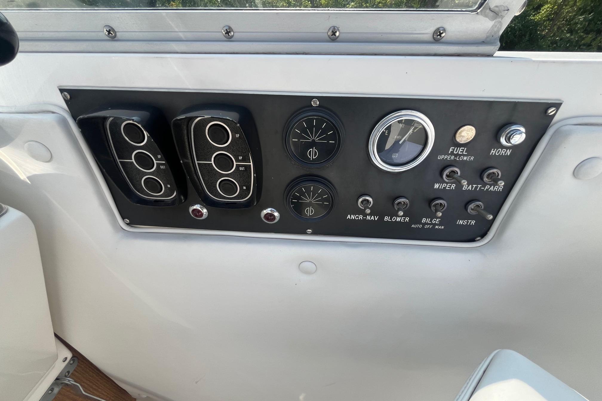 Control panel of a 1975 Bertram 26 Moppie boat with gauges and switches.