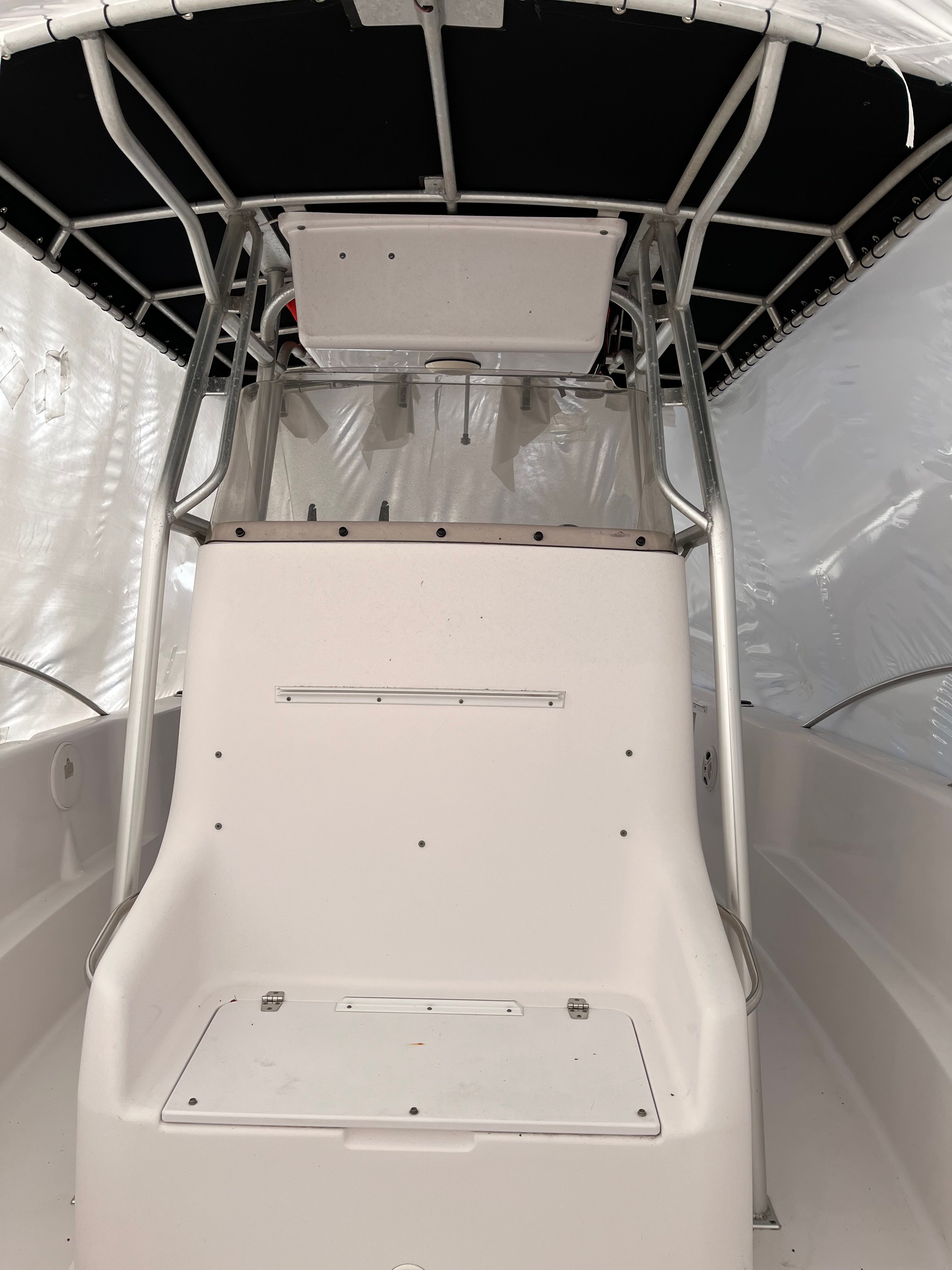 A 2002 Pro-Line Center Console boat with a white helm and black canopy.