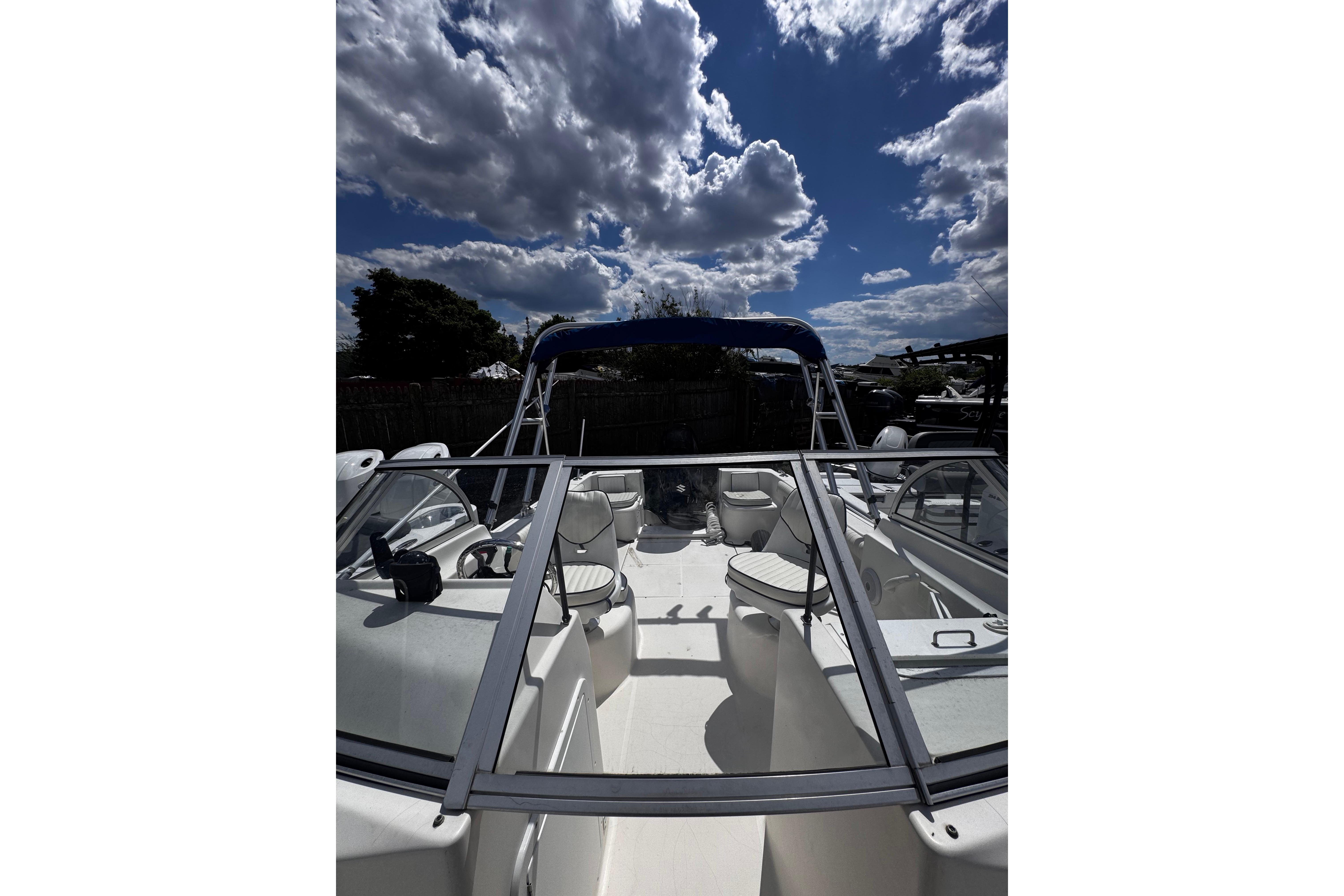 2003 Palm Beach 2200 Dual Console boat under a cloudy sky, showcasing seating and console.
