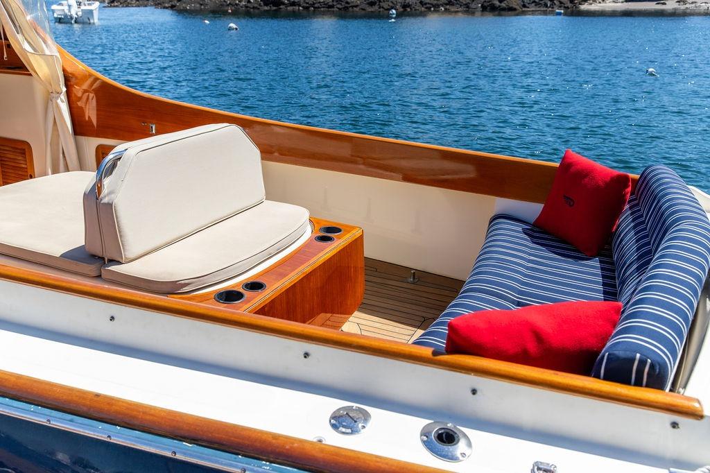Hinckley Picnic Boat 36 Classic 2000 with elegant seating, striped cushions, and scenic water view.