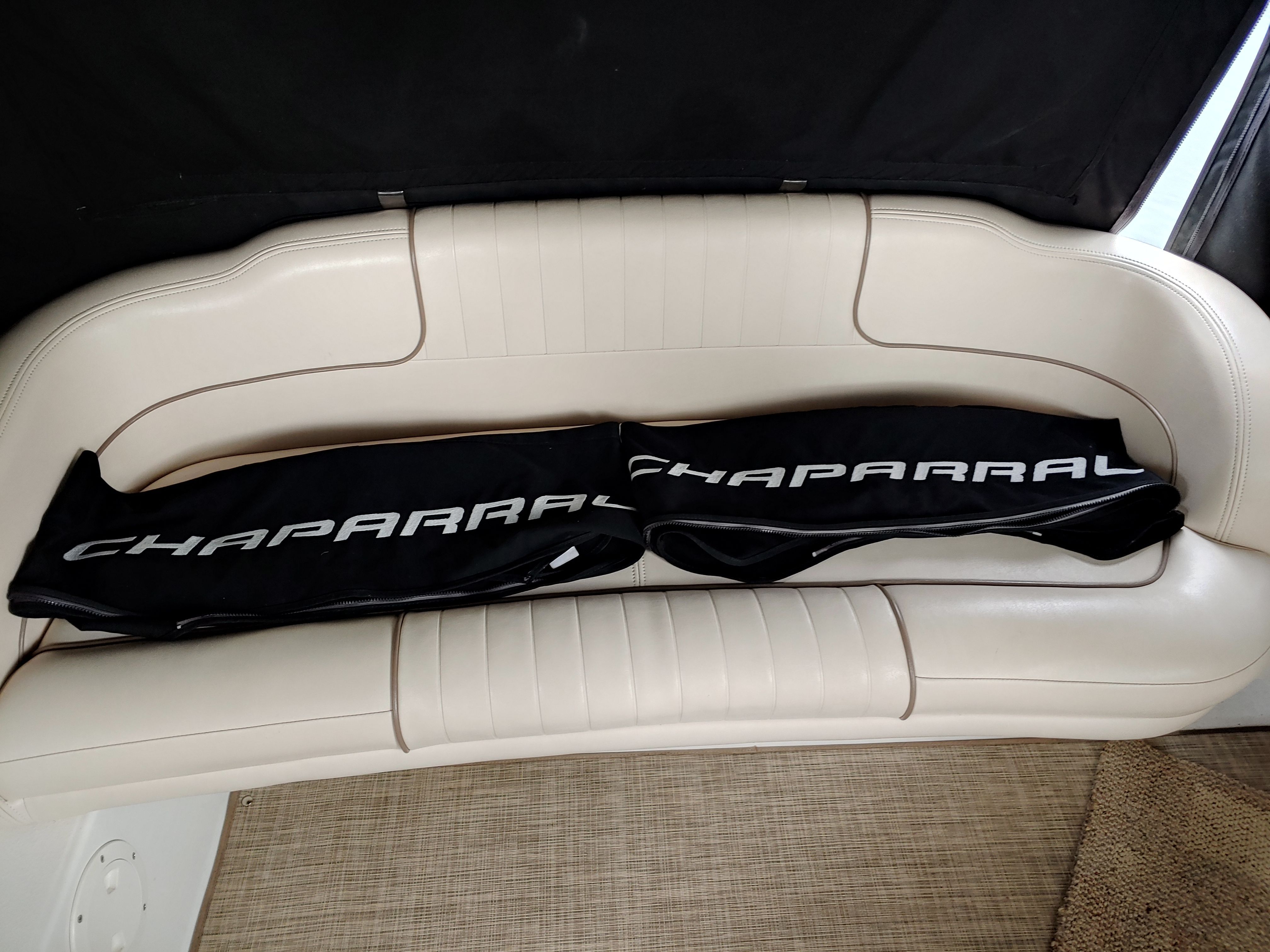 A cream-colored boat seat with a black cover displaying "CHAPARRAL."