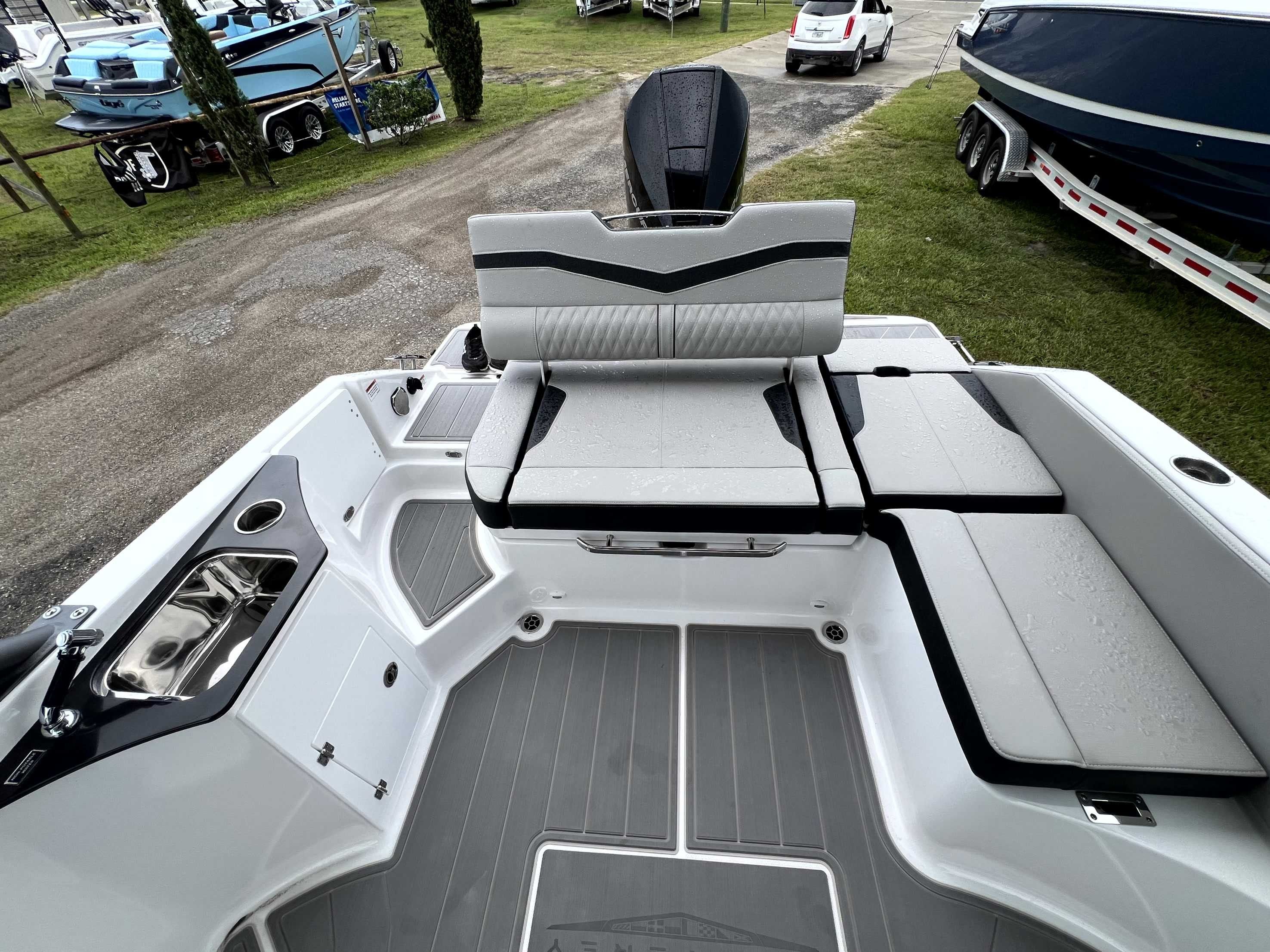The image shows the cockpit of a Monterey Elite 25 boat with gray upholstery and a sink.