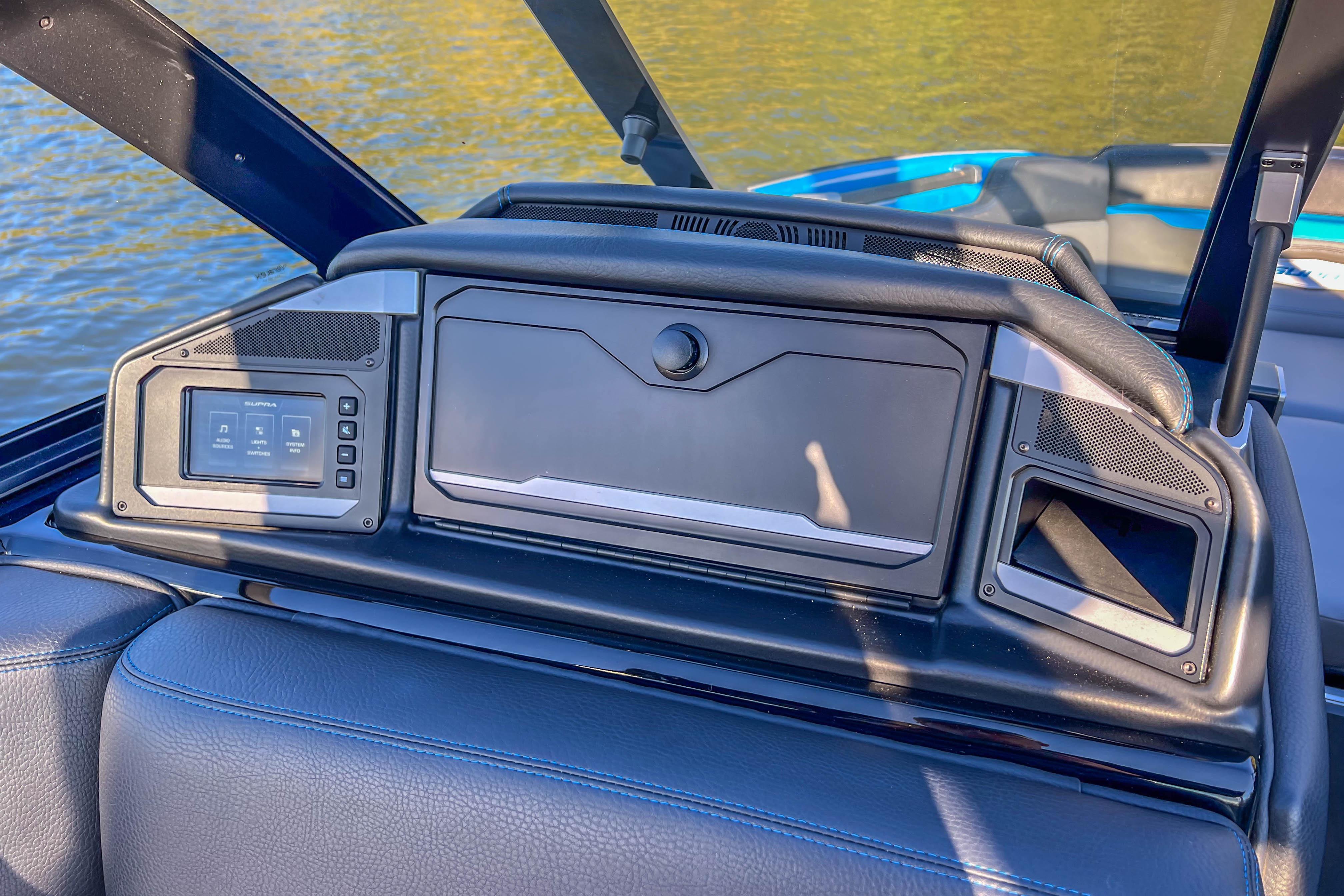 2024 Supra SV 400 boat dashboard with control panel and speakers, overlooking water.