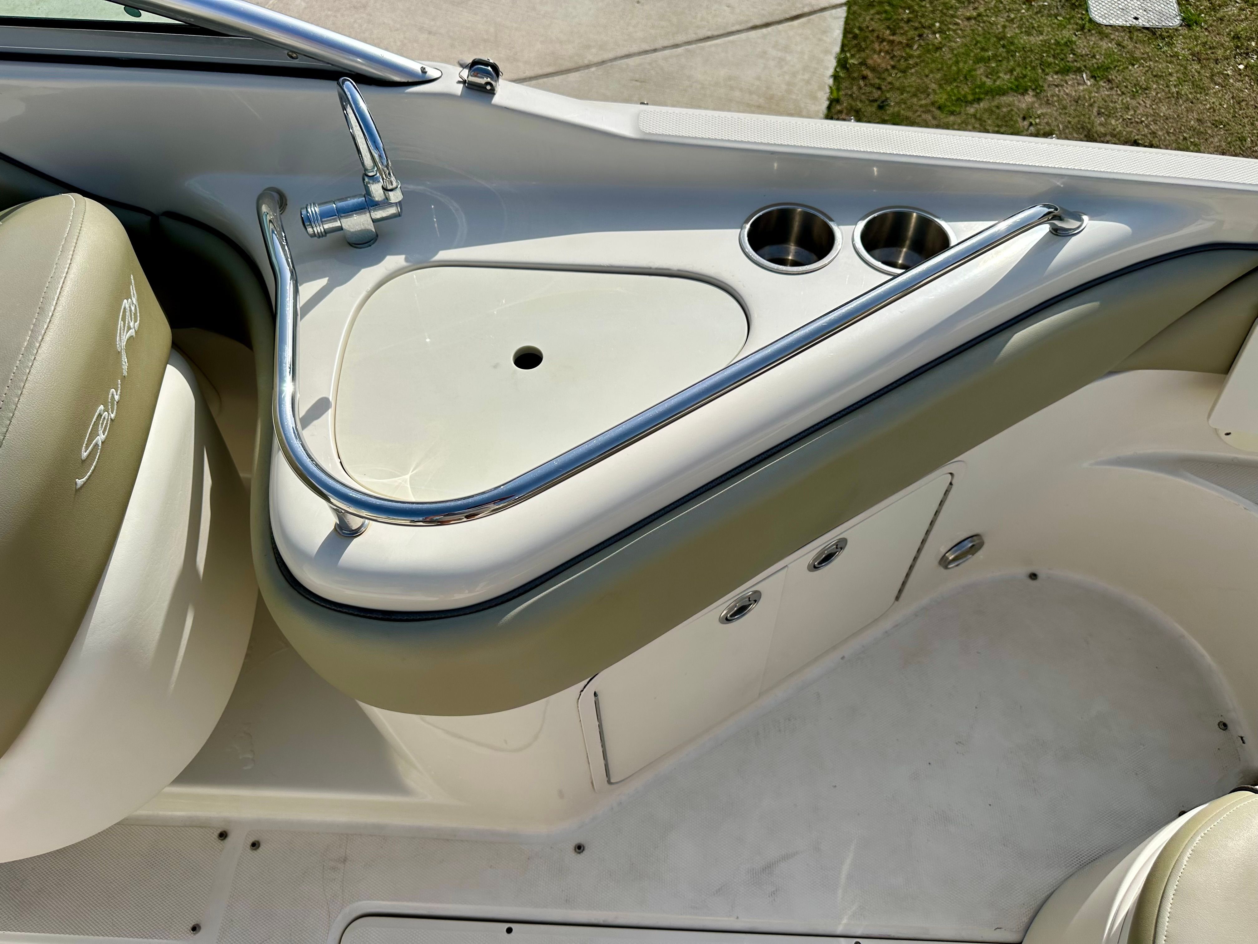 Interior of 2006 Sea Ray 240 Sundeck with sink and cup holders.