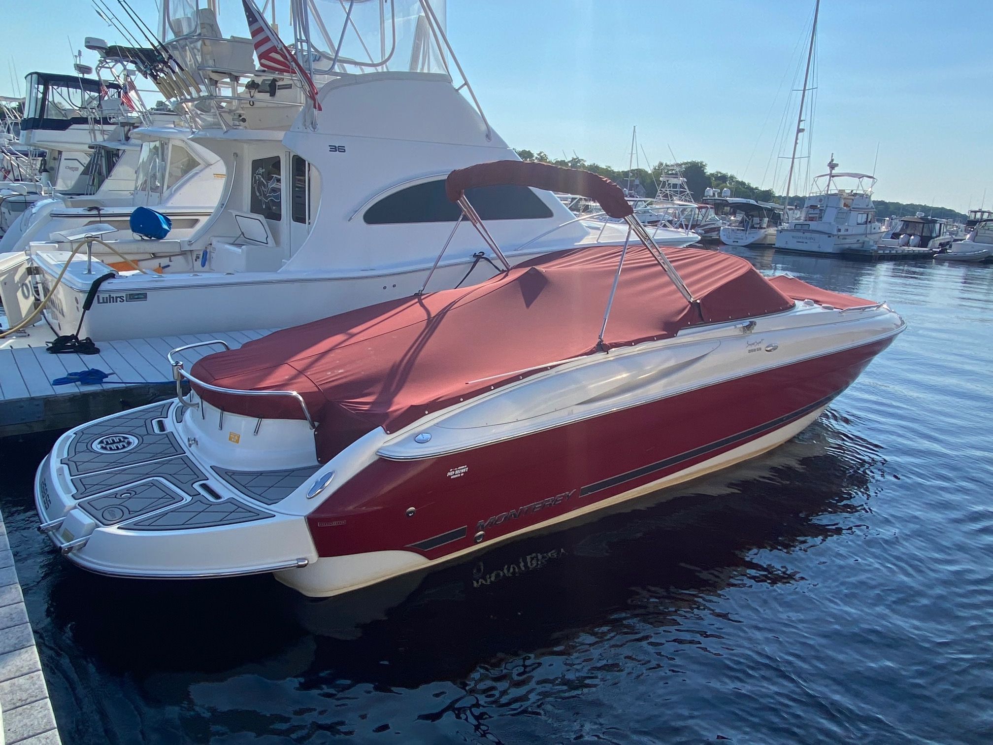 A red 2006 Monterey 268SS Super Sport boat docked, featuring a red cover.