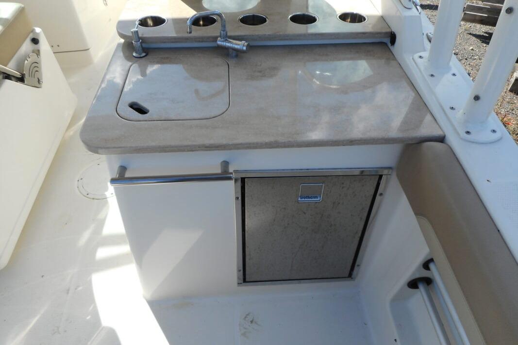 2020 Sailfish 275 DC boat kitchenette with sink and storage.