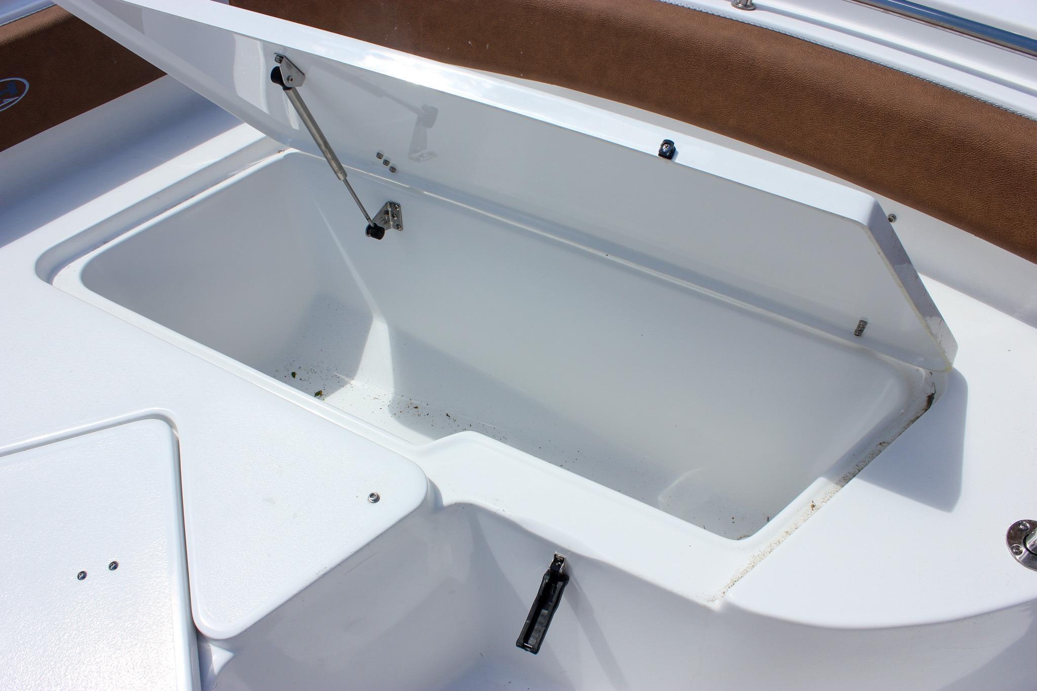Open storage compartment on 2027 Sea Hunt Ultra 234 boat, showcasing spacious interior.