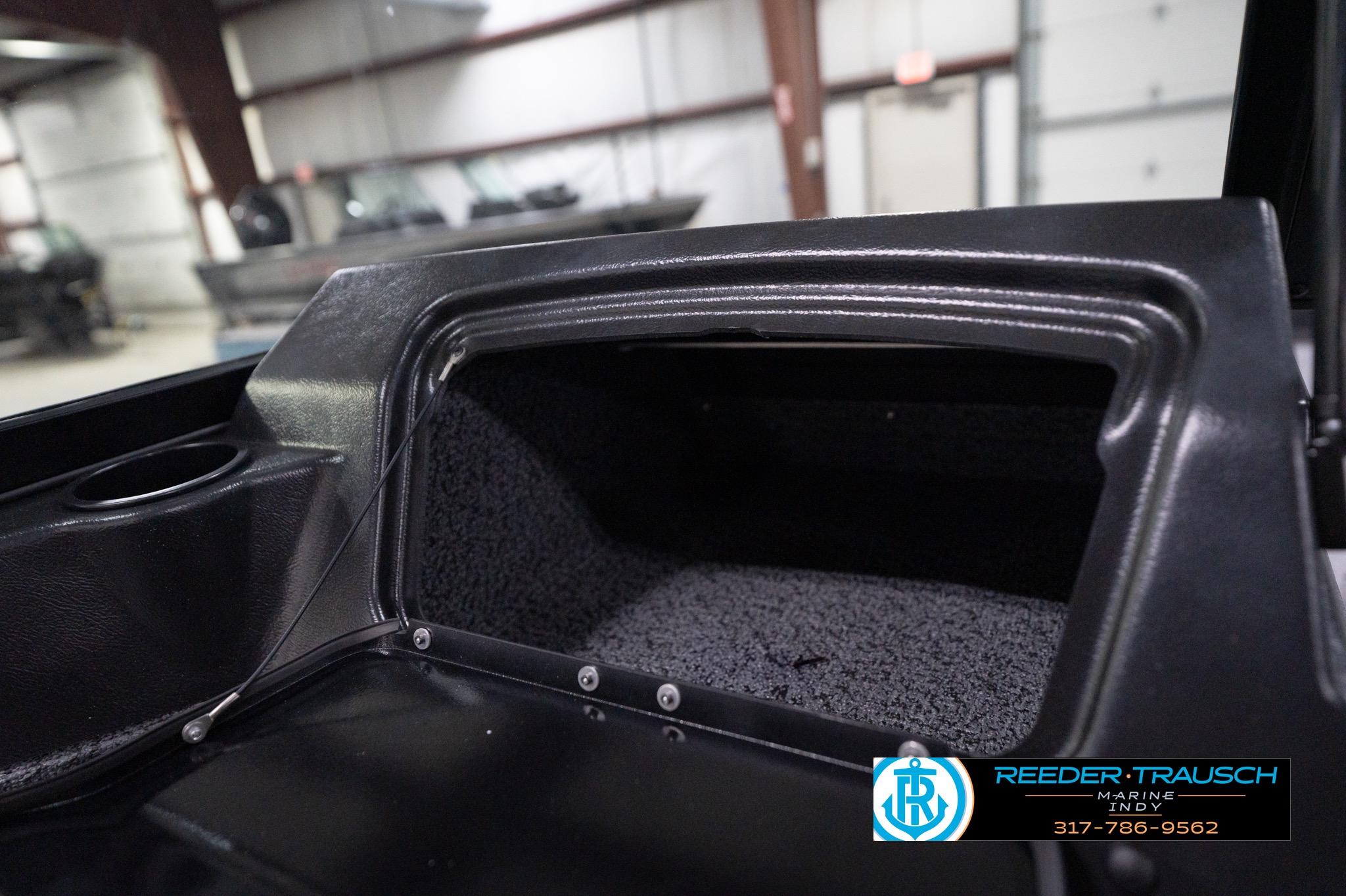 Interior storage compartment of 2026 Lund 1800 Explorer Sport boat, featuring carpeted lining.