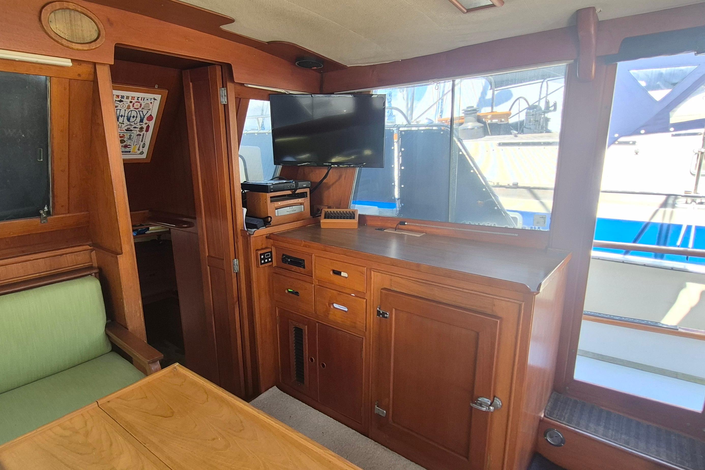 Interior of 1983 Grand Banks 42 Motoryacht with wood cabinetry and mounted TV.