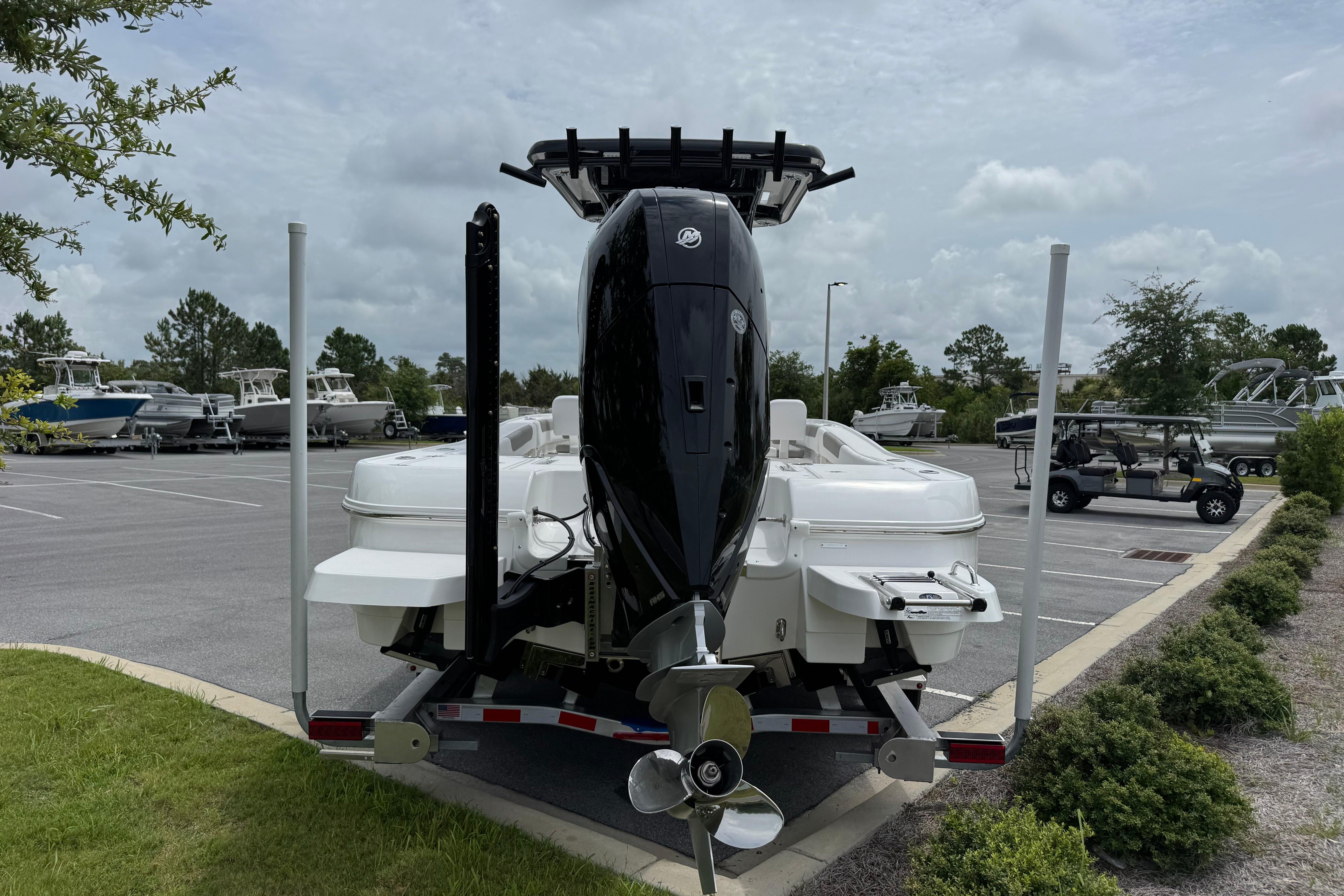 2027 Caymas 26 HB boat on trailer, parked in a lot with other boats.