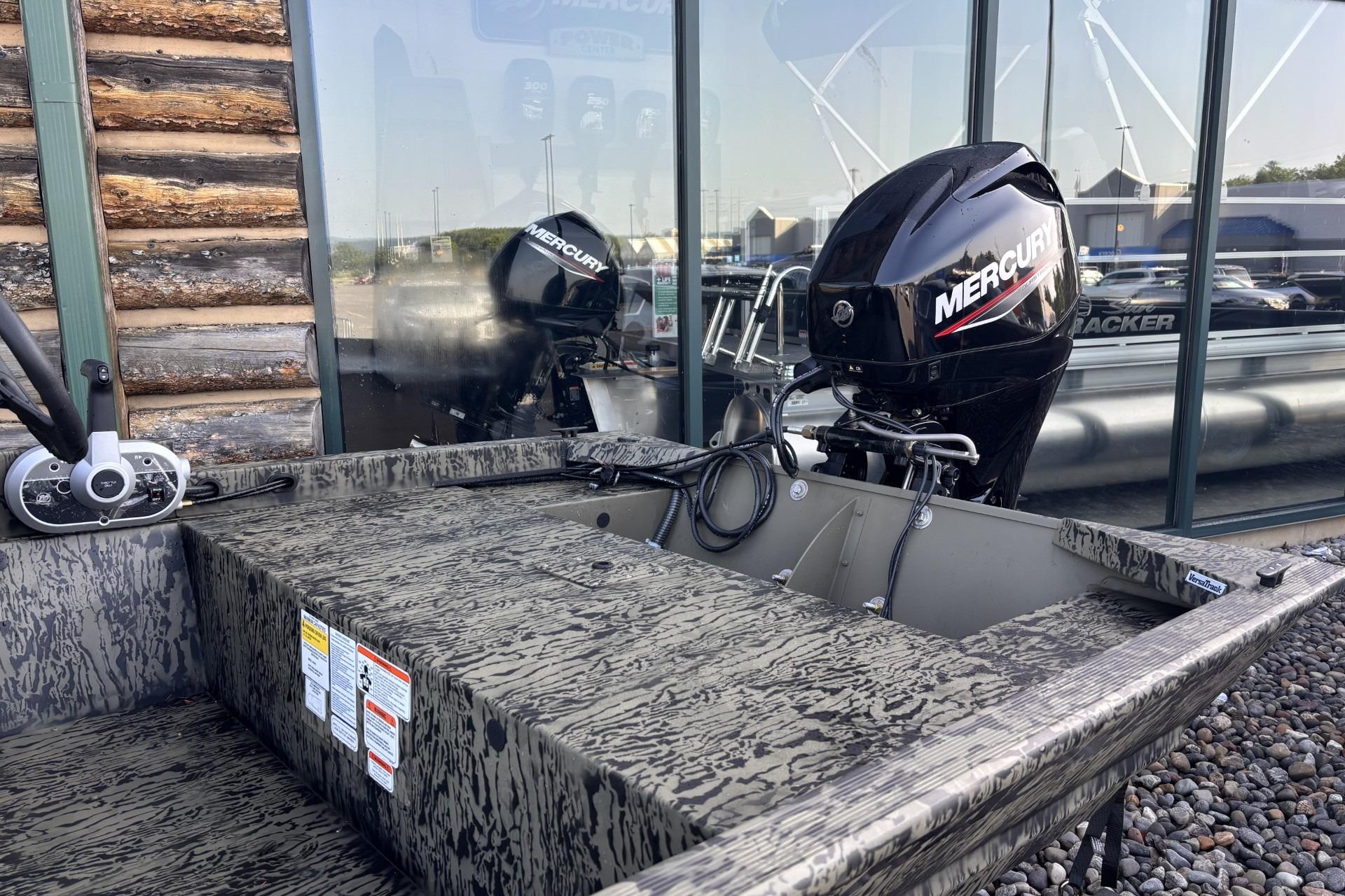 2026 Tracker Grizzly 1648 SC boat with Mercury outboard motor, parked outdoors.