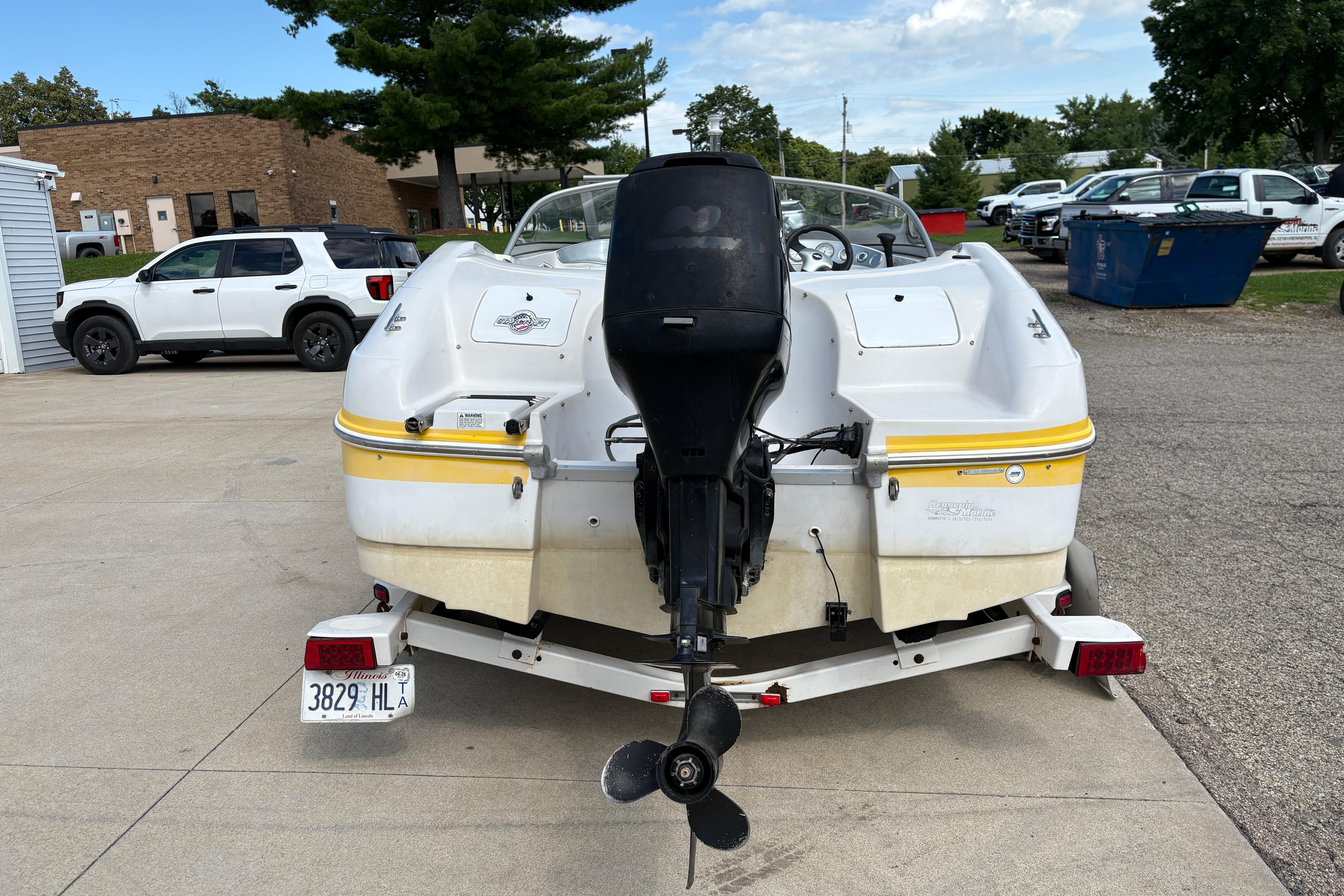 2005 Starcraft C-Star 1700 OB boat on trailer, parked outdoors near vehicles.