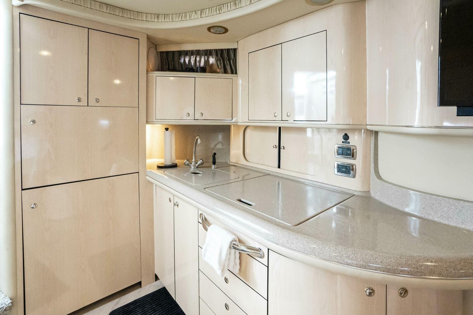 Luxurious kitchen interior of 2003 Sea Ray Sundancer 460 yacht with modern cabinetry.