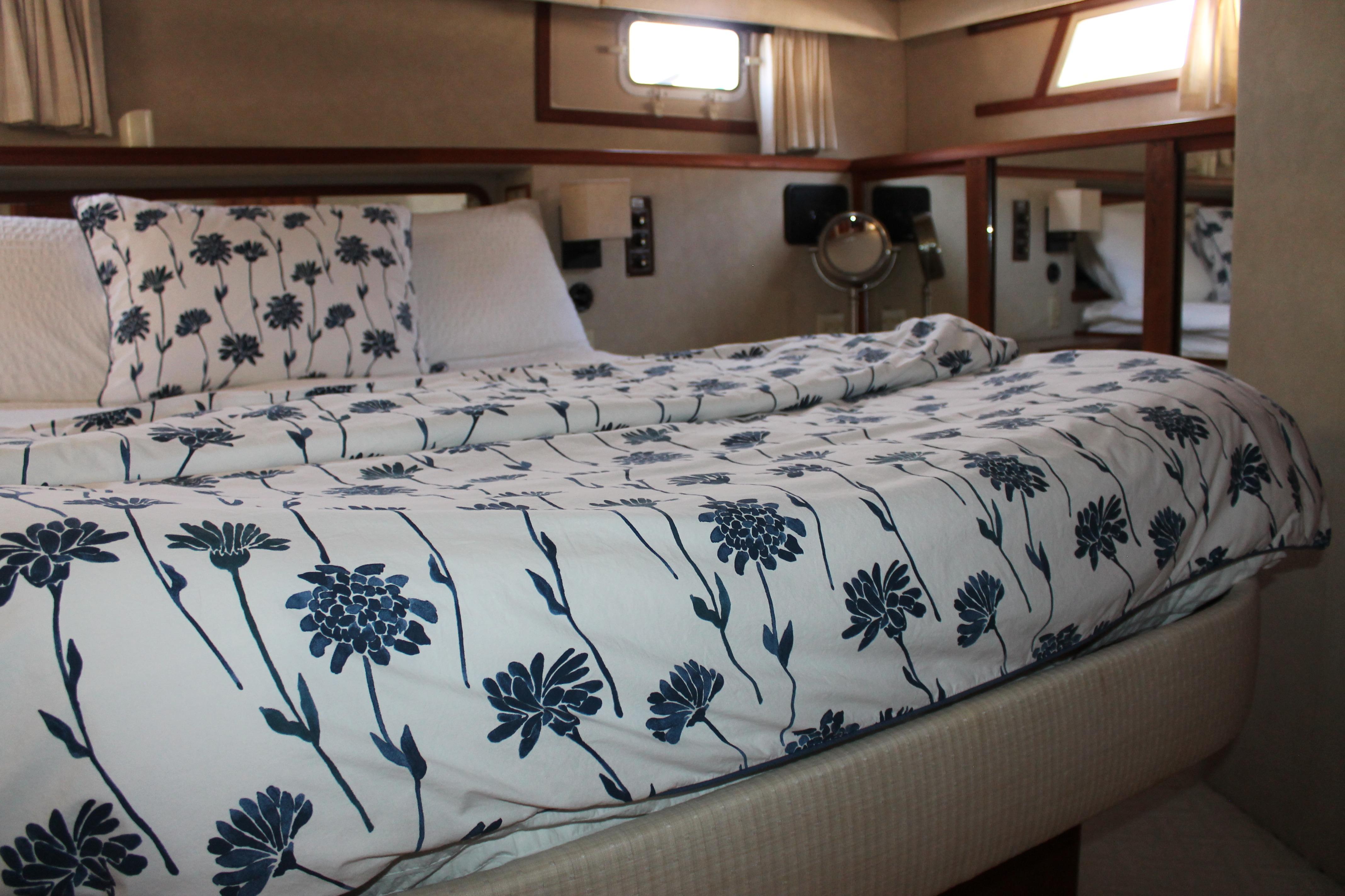 Cozy bedroom in 1987 Chris-Craft 427 Catalina with floral bedding and natural light.