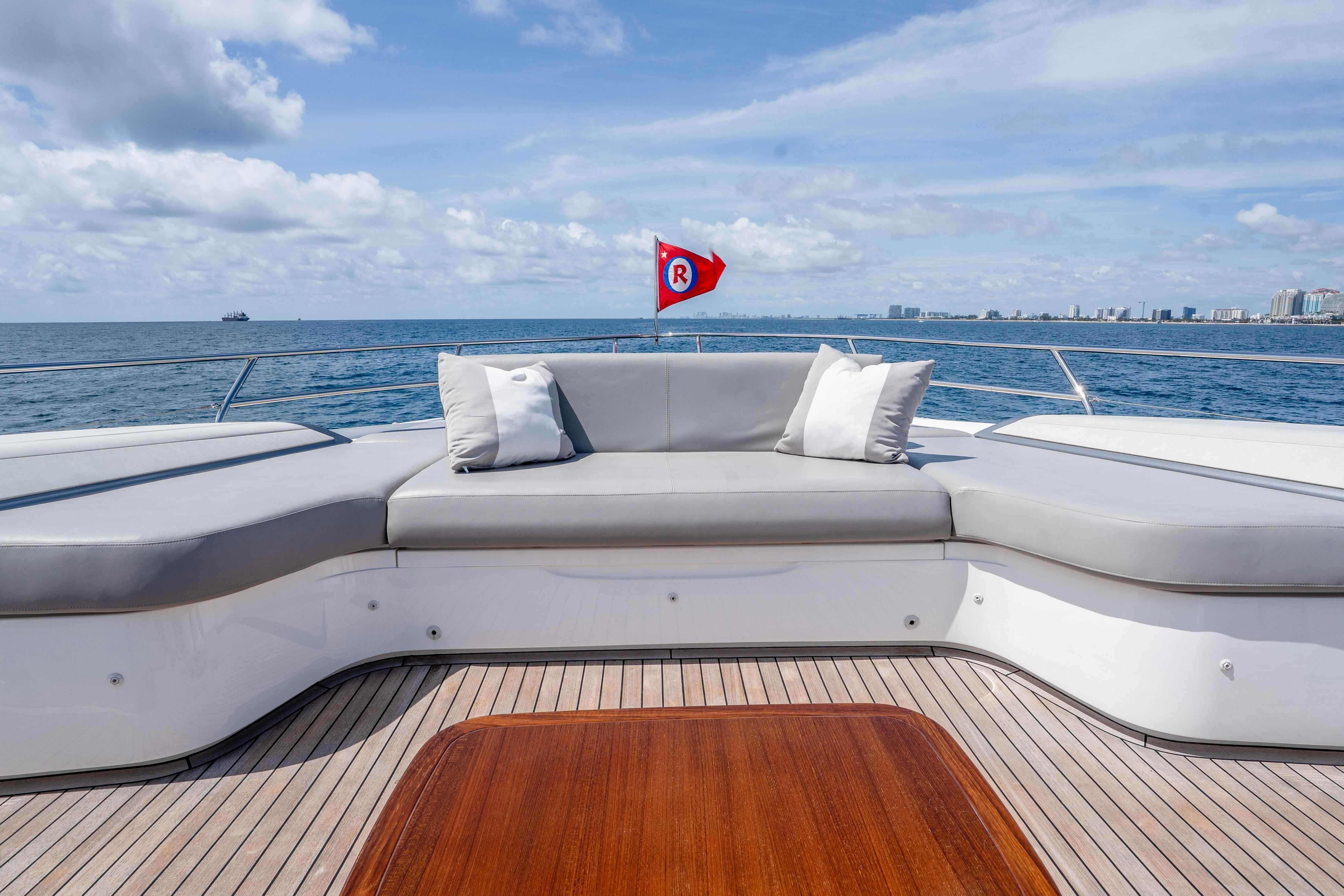 Luxurious 2020 Princess Y85 yacht deck with seating, ocean view, and city skyline in the background.