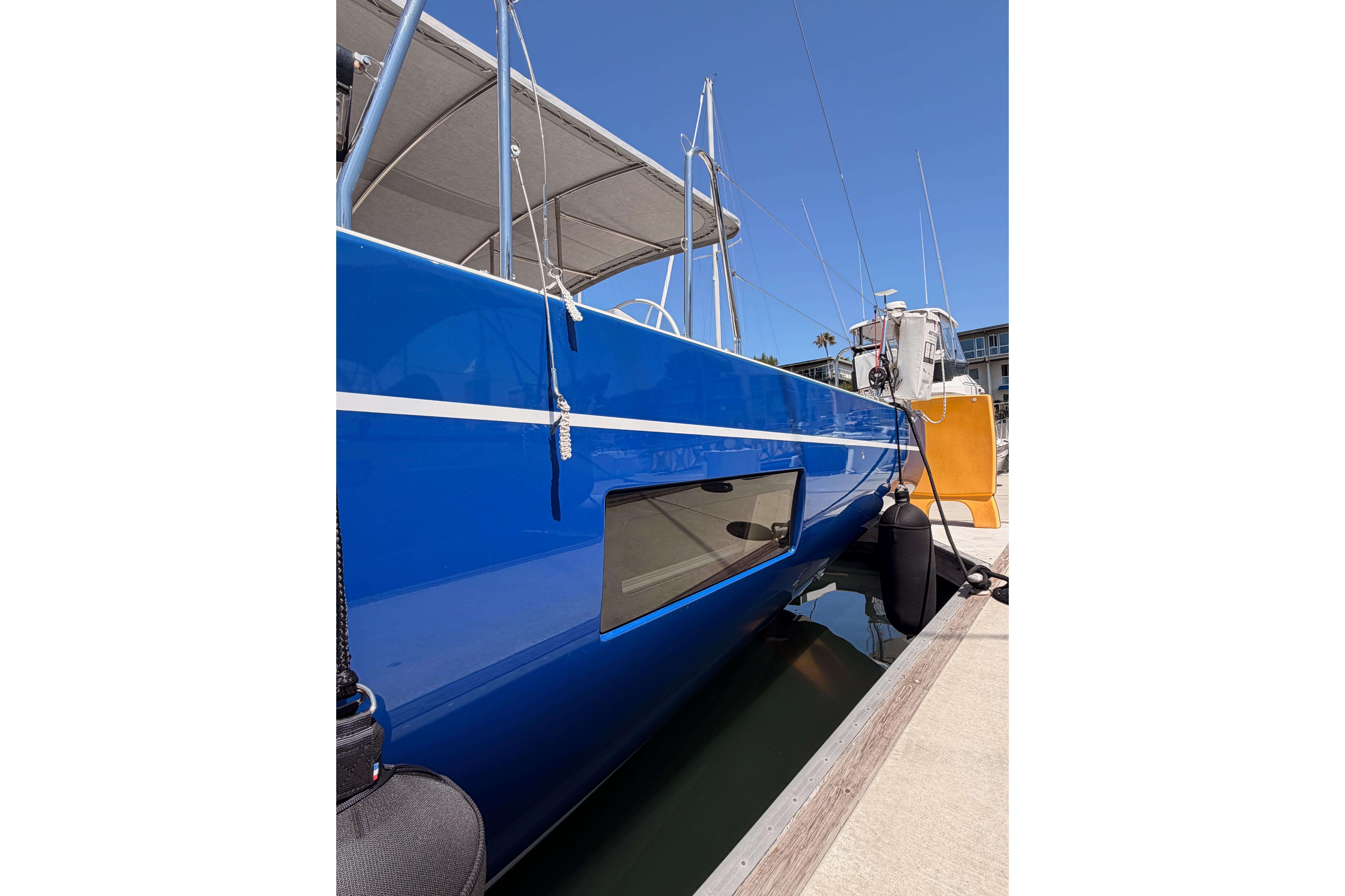 2022 Beneteau Oceanis Yacht 54 with sleek blue hull docked at marina.