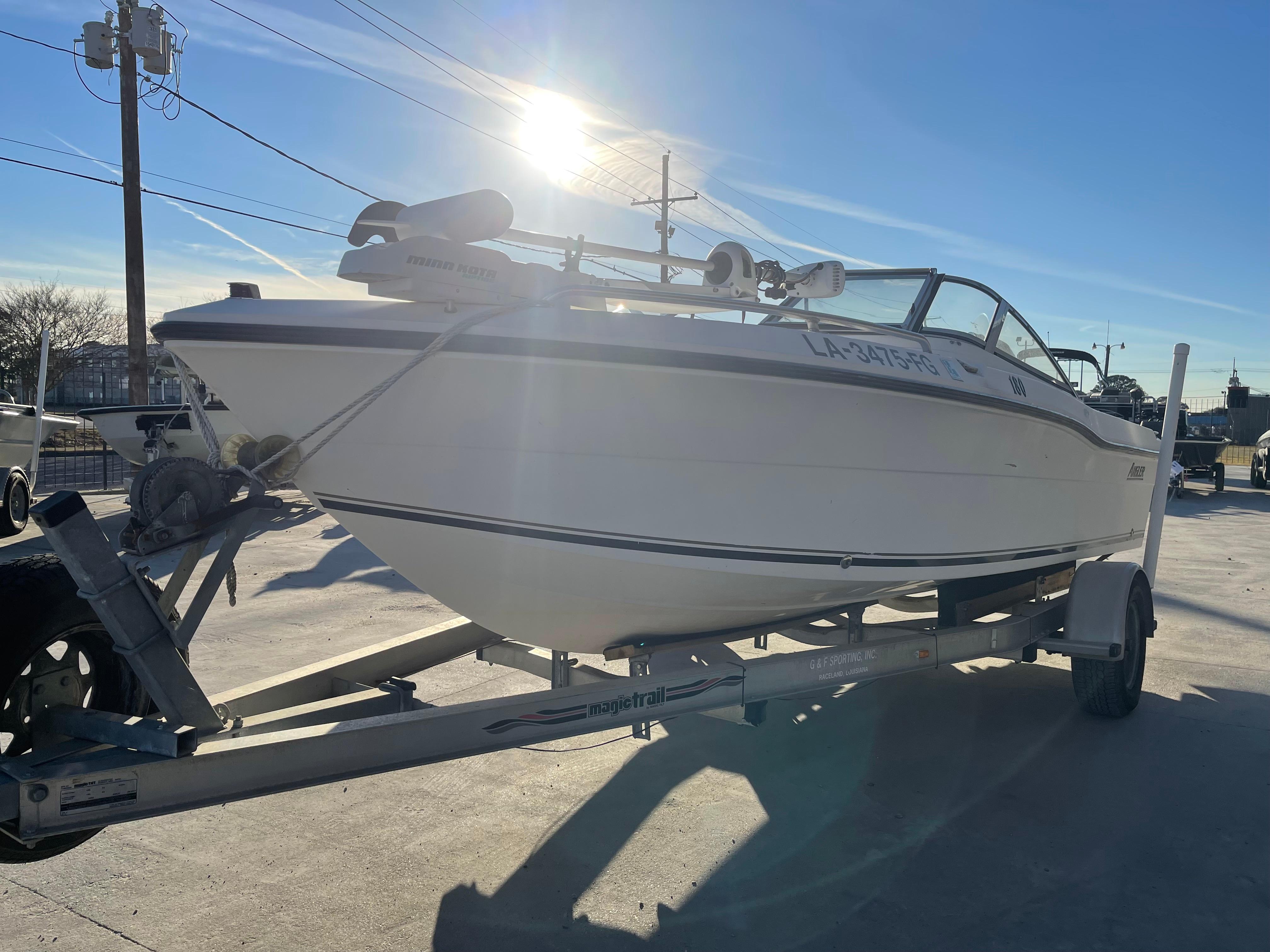 2002 Angler 18 DC boat on trailer, sunlit, parked outdoors.