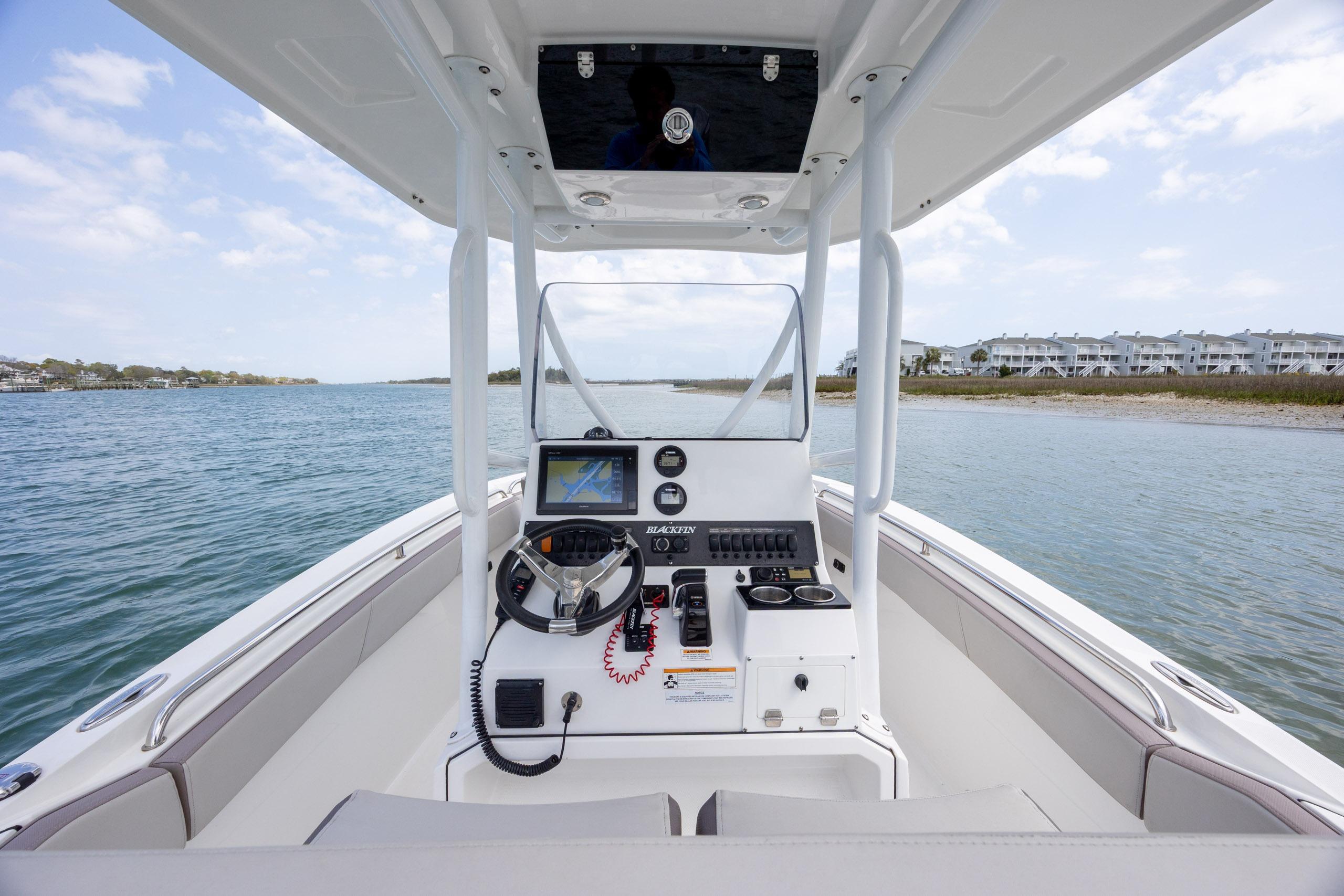 2019 Blackfin 212 CC boat interior with steering console on calm water.